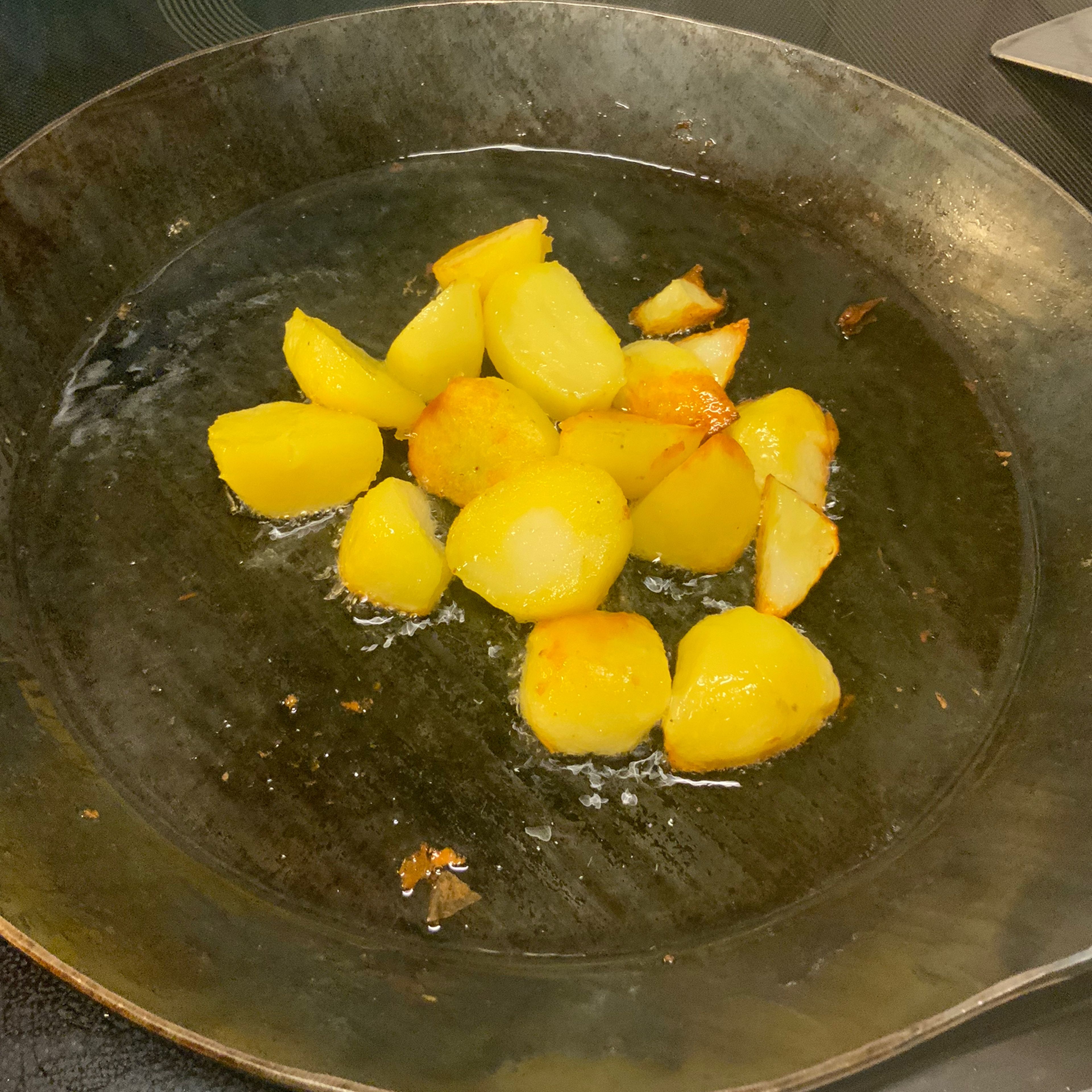 Während der Blumenkohl/Brokkoli überbäckt die Bratkartoffeln zubereiten. In einer Eisenpfanne wenig Butterschmalz schmelzen und heiß darin die Bratkartoffeln anbraten bis sie ne schöne Bräune bekommen.