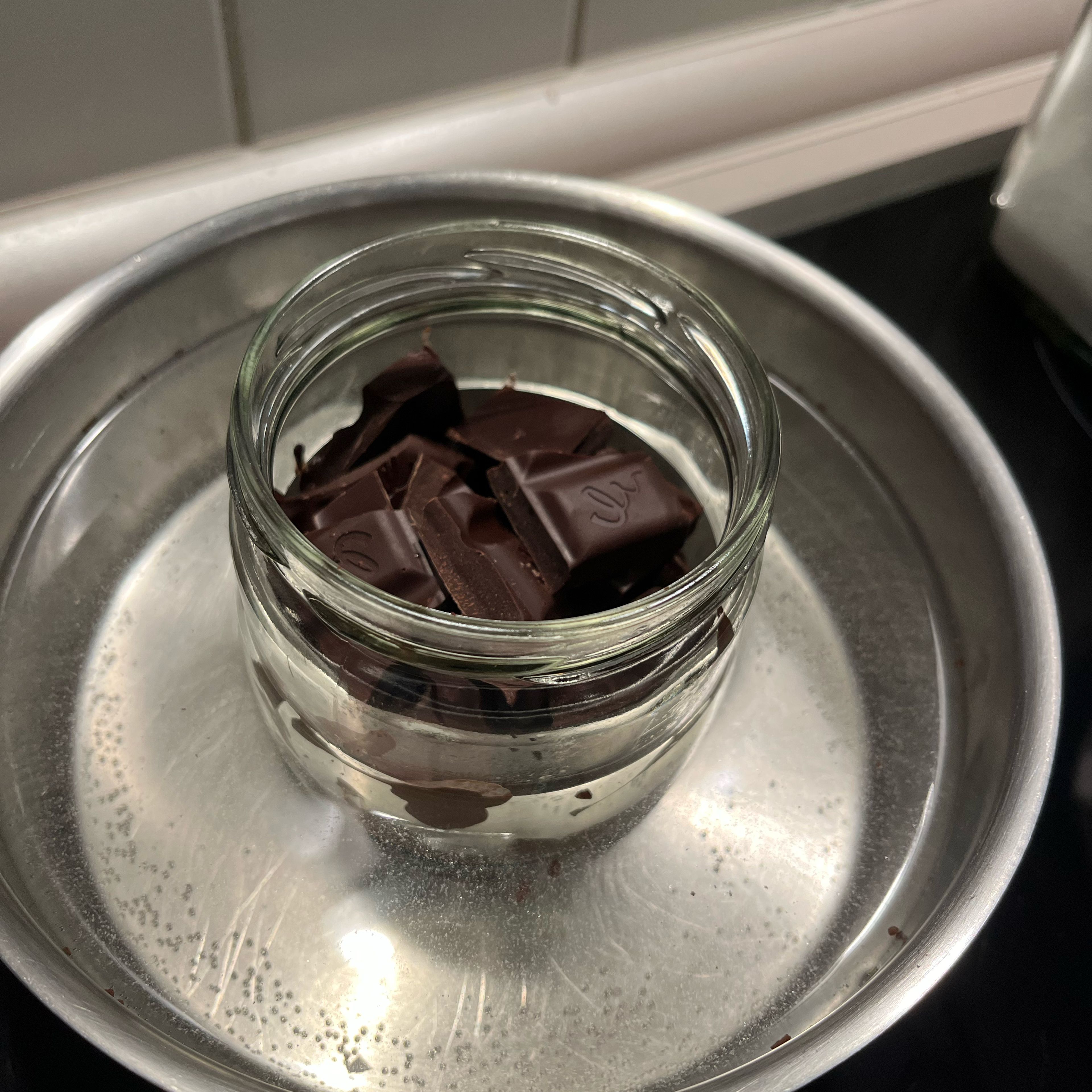 Schokolade über dem Wasserbad langsam schmelzen und mit der geschmolzenen Butter verrühren.
