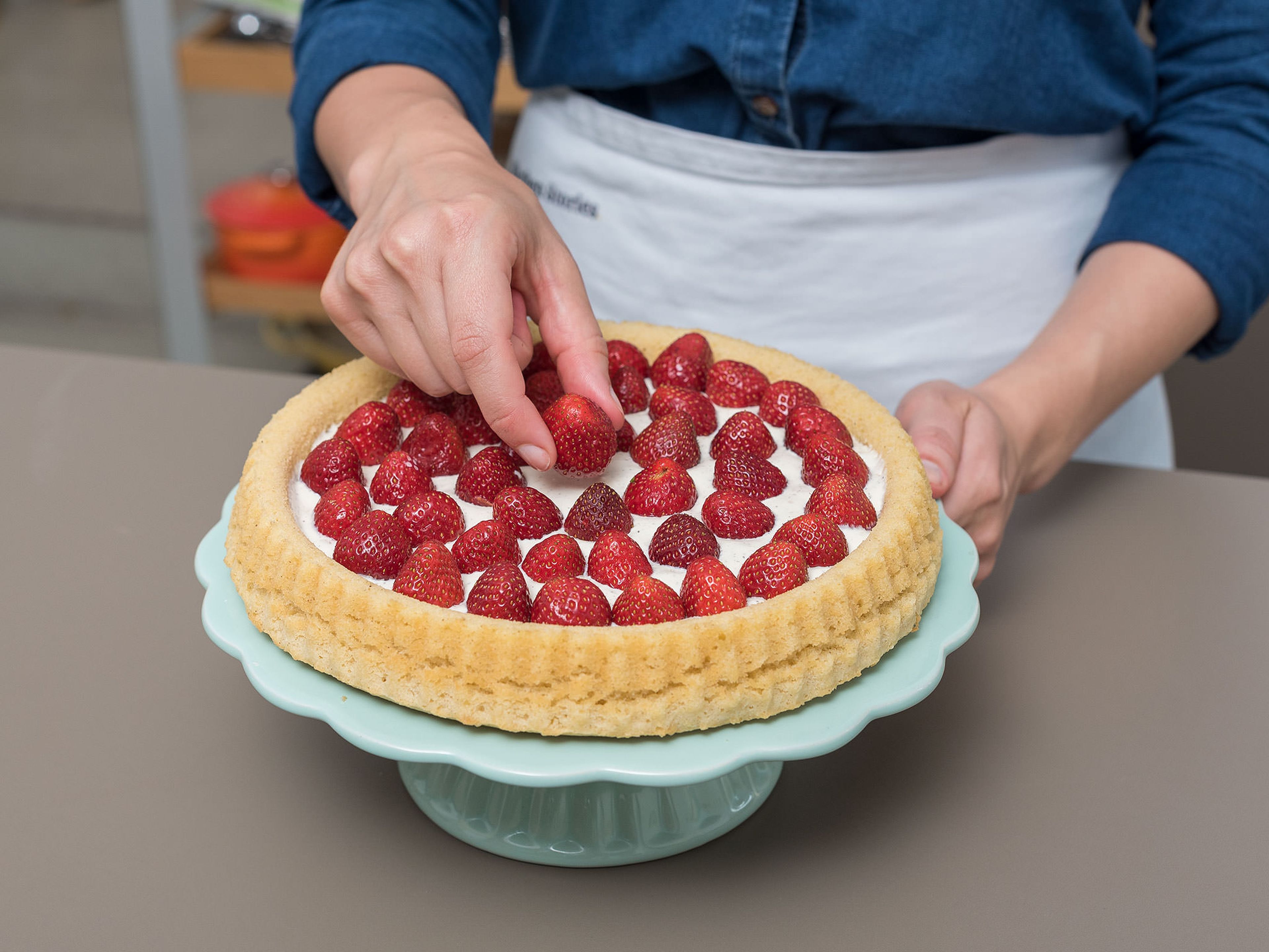 Einen Teller auf die abgekühlte Backform legen und den Kuchenboden auf den Teller stürzen. Die verfeinerte Mascarpone auf den Kuchenboden streichen und die Erdbeeren darauf verteilen. Mit gerösteten, gehobelten Mandeln bestreuen und mit Minzblättern dekorieren. Guten Appetit!