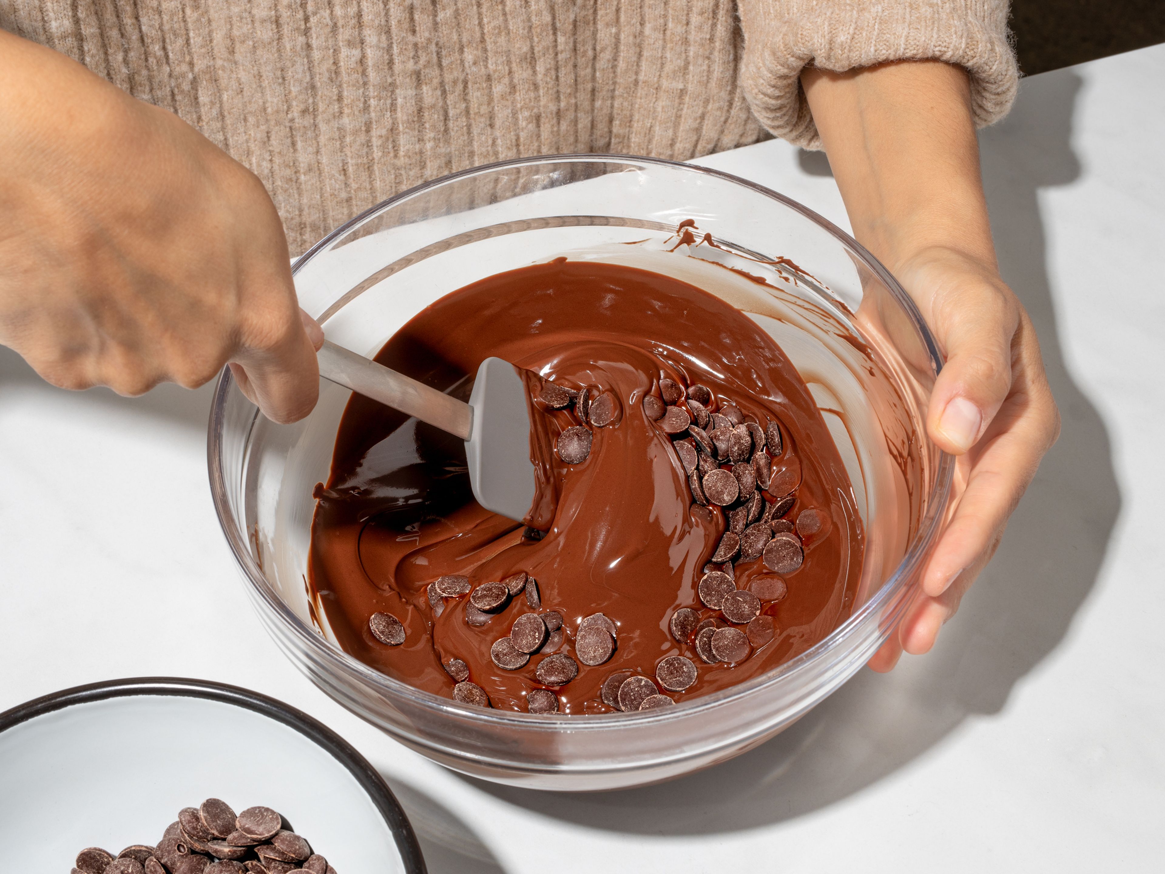 Zartbitter- und Vollmichschokolade hacken (alternativ können auch ungehackte Schokodrops verwendet werden) und jeweils ein Drittel der Schokolade zum Temperieren beiseitestellen. Zwei Drittel der Schokolade jeweils in einer hitzebeständigen Schüssel über einem Topf mit köchelndem Wasser schmelzen. Die geschmolzene Schokolade vom Herd nehmen und jeweils das übrige Drittel darin schmelzen lassen. Ca. 10 Min. abkühlen lassen, dabei gelegentlich mit einem Gummispatel umrühren. In der Zwischenzeit ein Backblech mit Backpapier auslegen und mit etwas Goldstaub besprühen. Dabei eventuell die Ecken des Backpapiers mit etwas flüssiger Schokolade fixieren, um ein Verrutschen des Backpapiers zu verhindern.