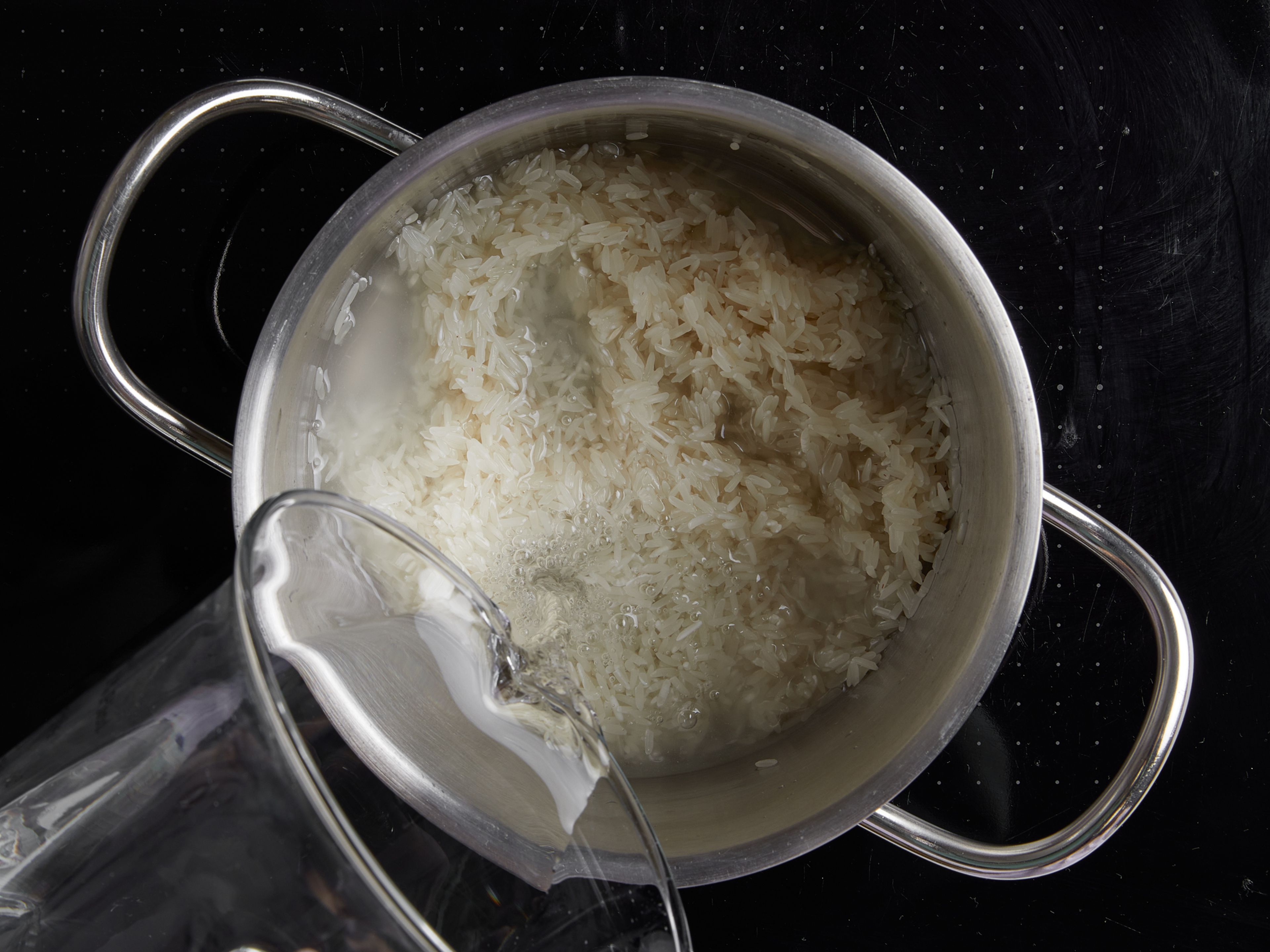Wash and rinse the rice in a fine sieve until the water runs clear, then transfer to a pot with a lid. Add water, cover with a lid, and bring to a boil. Once boiling, reduce heat to low and cook for approx. 10 min. After the cooking time, remove from heat, keeping covered, and set aside.