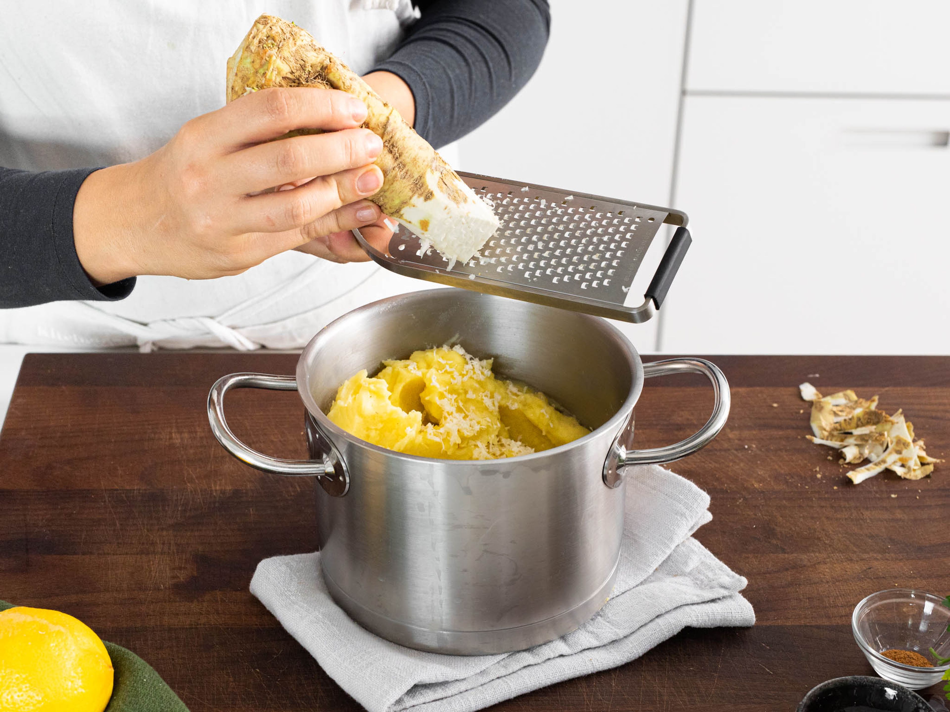 At the same time, use a potato ricer to mash cooked potatoes. Heat remaining butter and milk, nutmeg, and salt in a small saucepan, then stir in with the mash. Grate some horseradish over it.