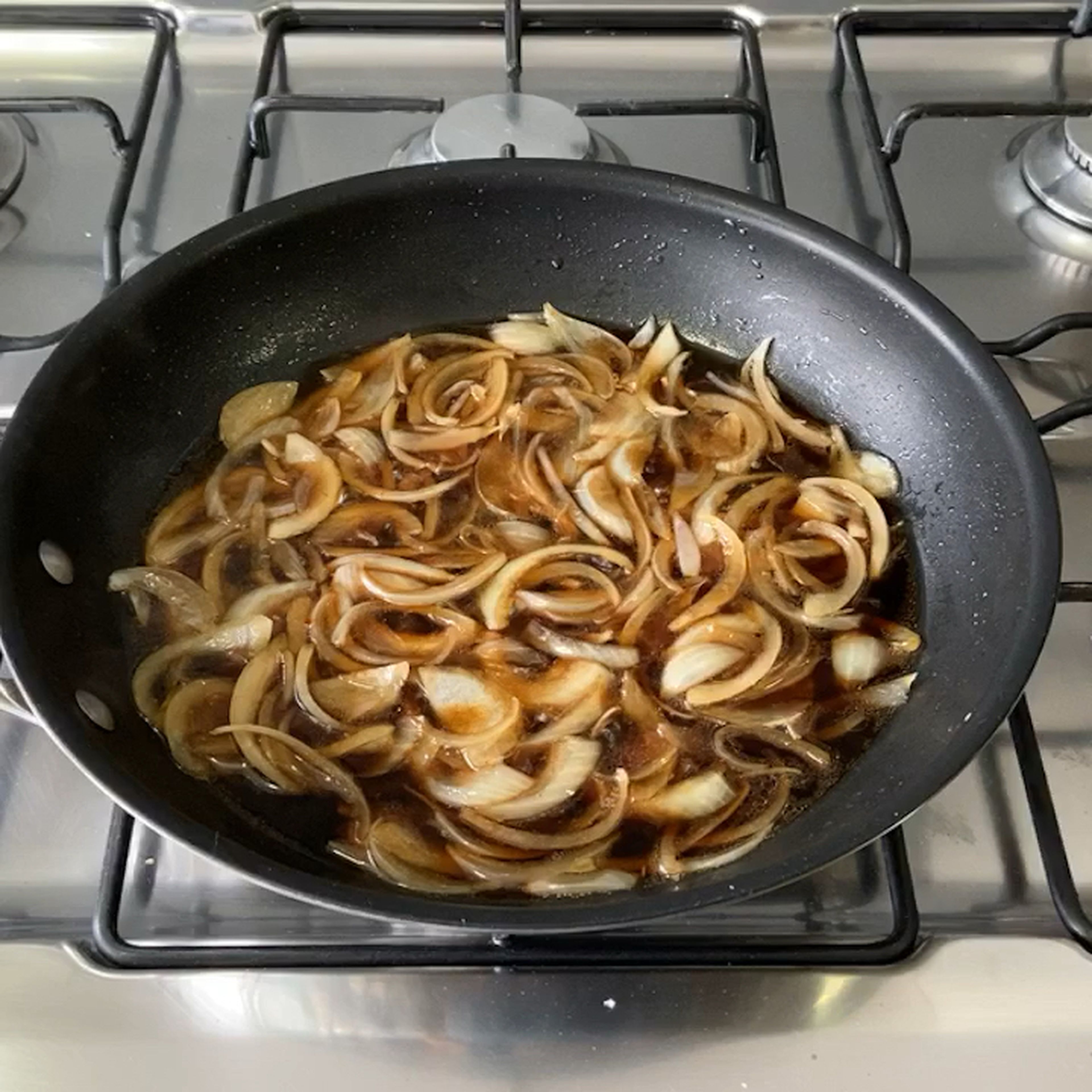 In your largest shallow frying pan, cook the onion slices in olive oil on medium heat until translucent and then add the dashi/sugar/soy mixture. Let simmer until there is about 1/4 cup of liquid remaining in the pan. ****Note: again if you are serving all 4 cutlets at once you will need to either have two frying pans going at once or cook two portions and keep them warm until the other two portions are ready.