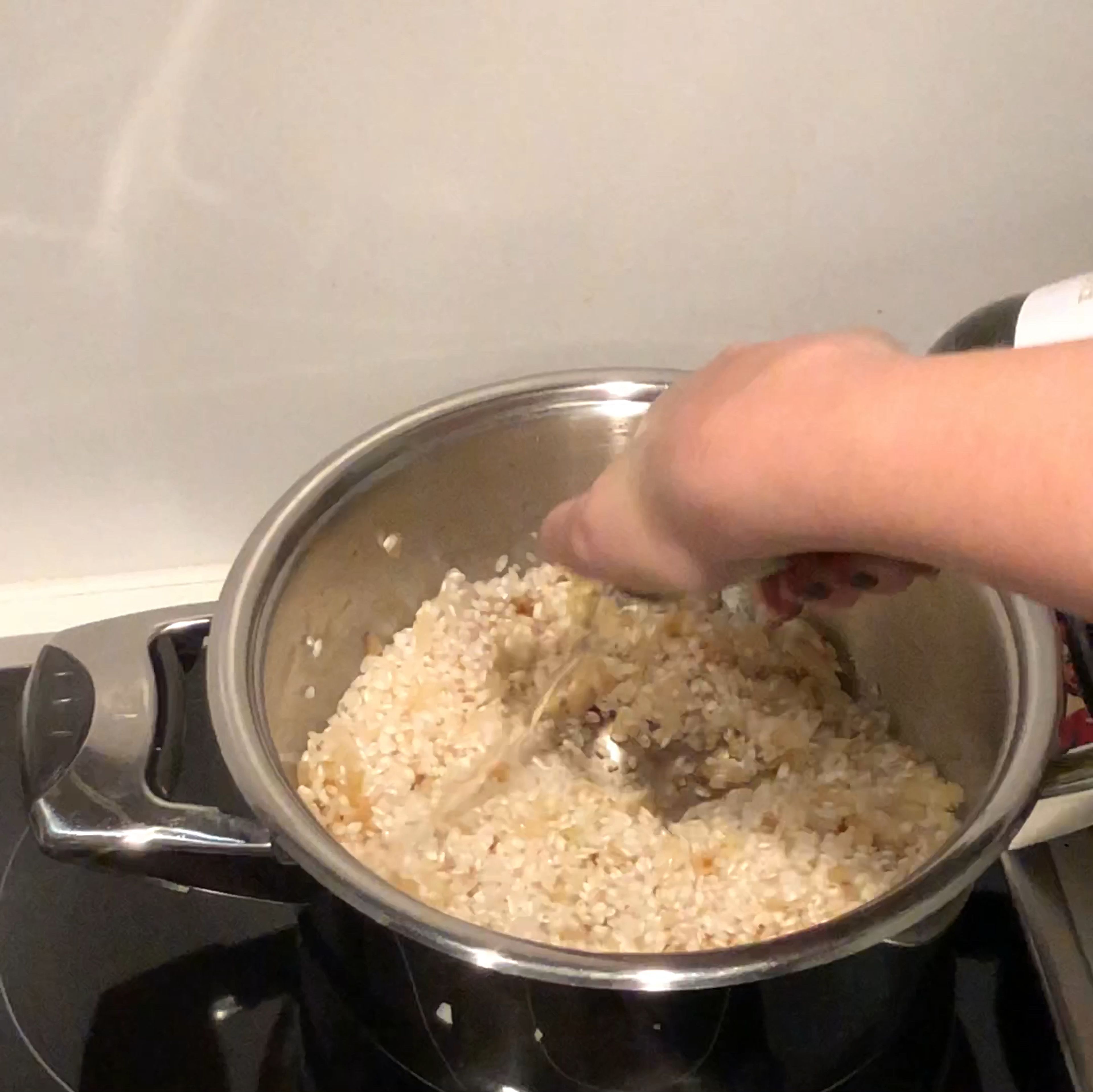 Sobald die Zwiebeln glasig sind (ca. 3 Min.) den trockenen Risottoreis dazugeben und kurz anbraten. Anschließend mit Weißwein ablöschen. Den Weißwein unter stetigem Rühren verkochen lassen.