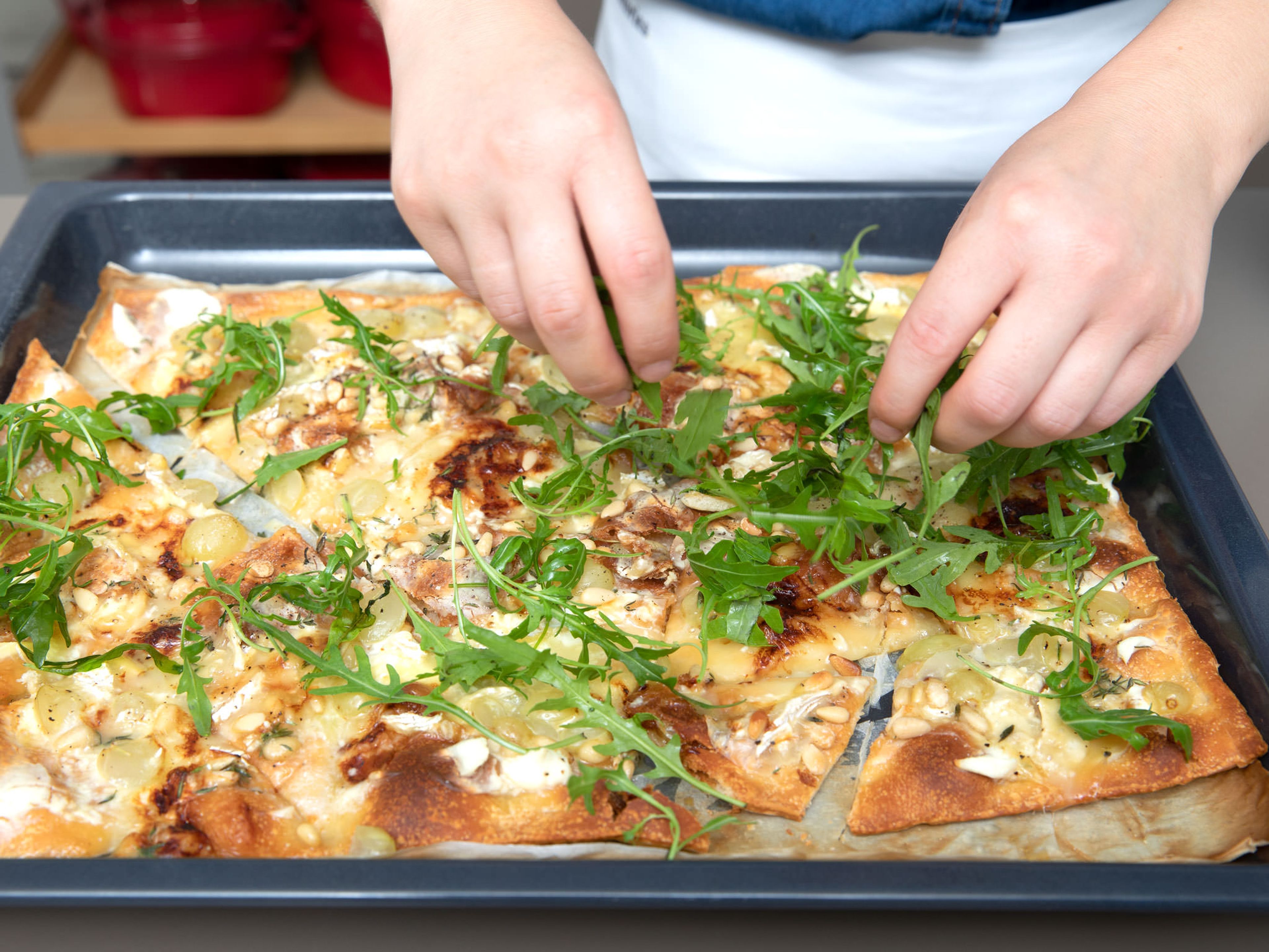 Die Pizza zurück in den Backofen geben und bei 240°C ca. 6 - 8 Min. auf der untersten Schiene weiter backen, oder bis der Briekäse beginnt zu schmelzen und der Pizzarand knusprig ist. Aus dem Backofen nehmen und frischen Rucola auf der Pizza verteilen. Guten Appetit!