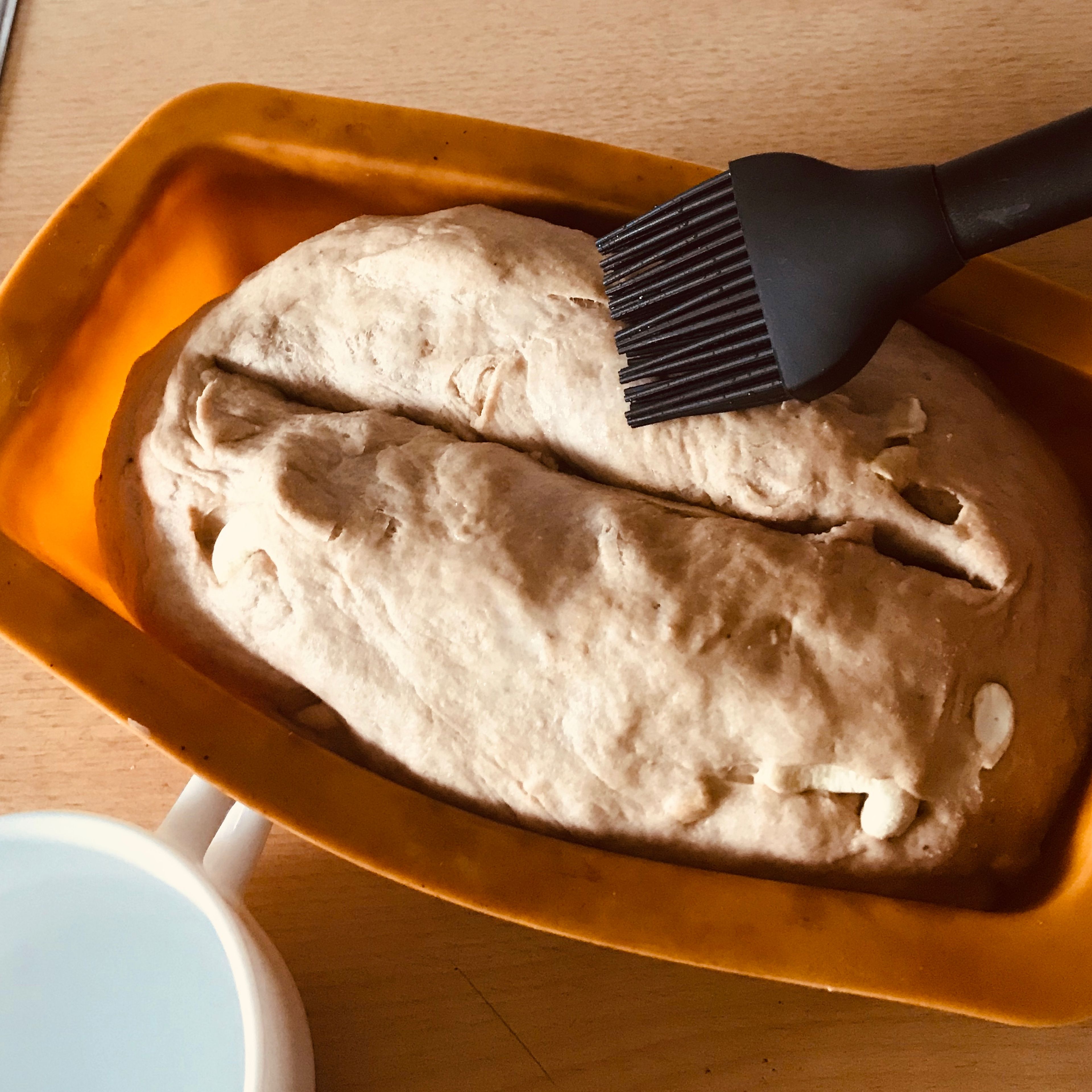 Den Teig in eine Kastenform geben und mit einem Messer längs ca. 1cm tief einschneiden. Anschließend mit Wasser bestreichen und in den Ofen schieben.