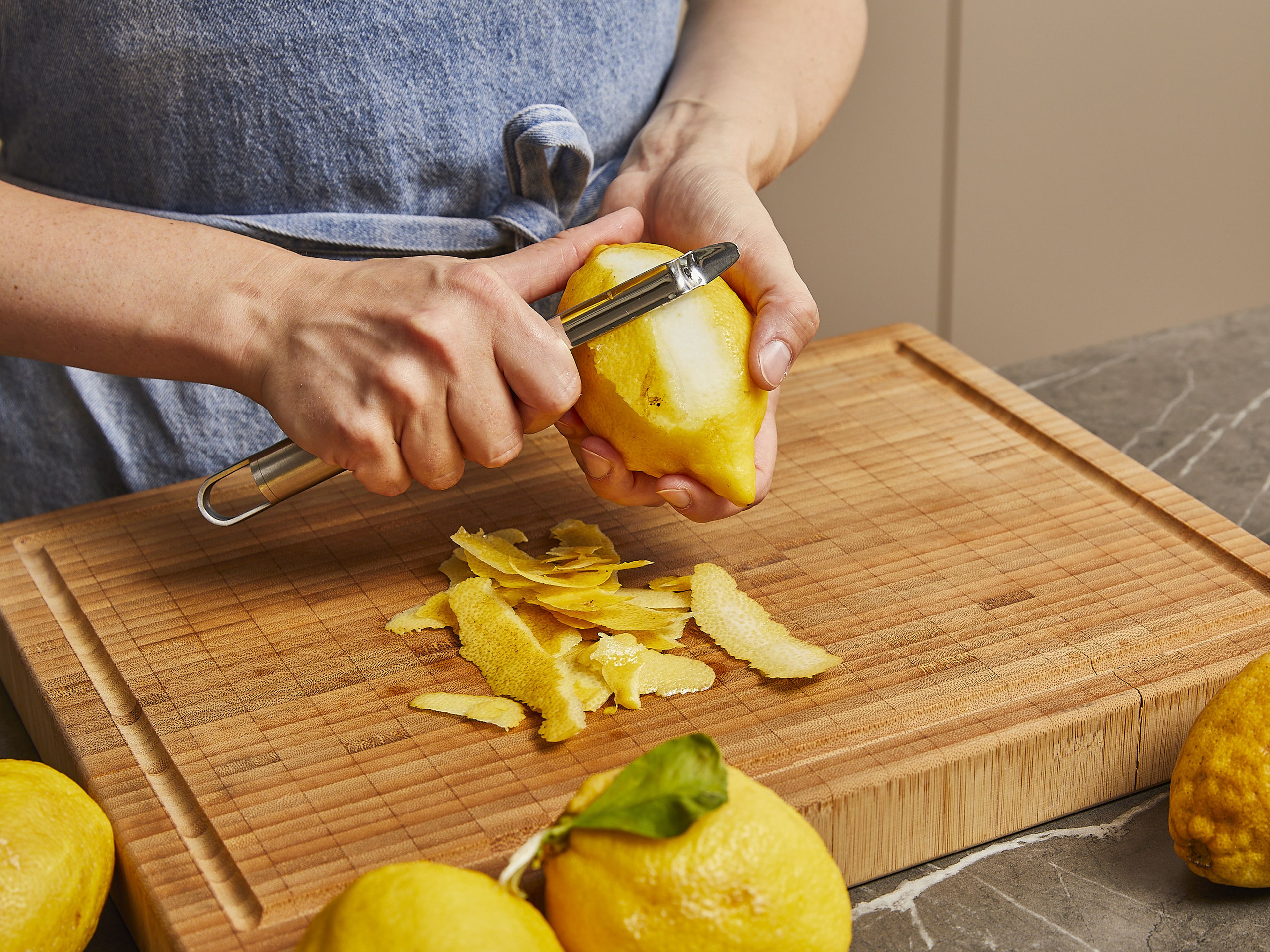 Für den Limoncello, die frischen Zitronen gründlich mit heißem Wasser waschen und abtrocknen. Zitronenschale mit einem Sparschäler schälen. Darauf achten, dass nicht zu viel von der weißen Haut abgeschält wird, damit er nicht zu bitter wird.