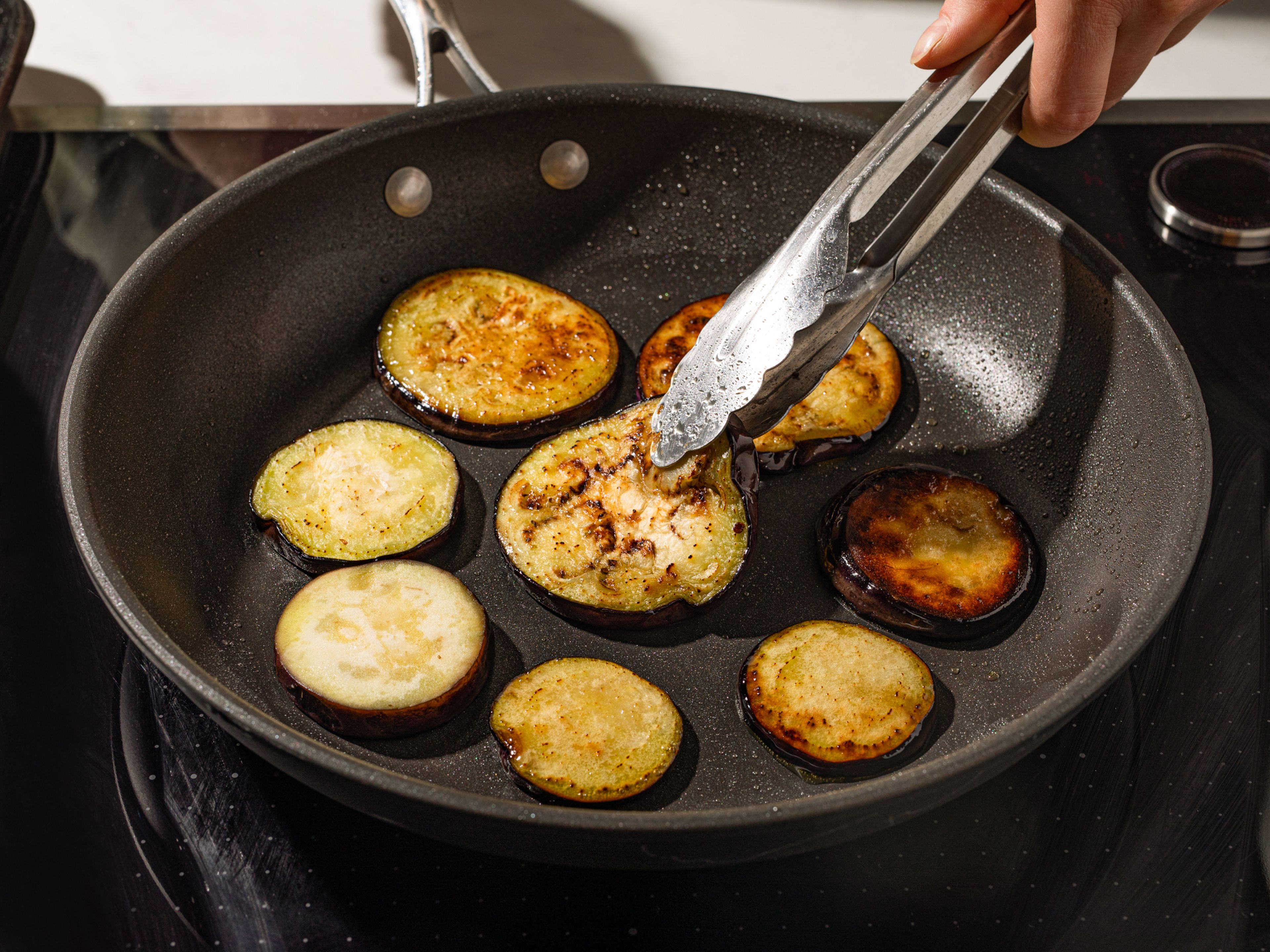 Drain and pat-dry the eggplant with paper towels. Heat olive oil in a nonstick pan, then add eggplant. Fry on both sides until browned and soft.
