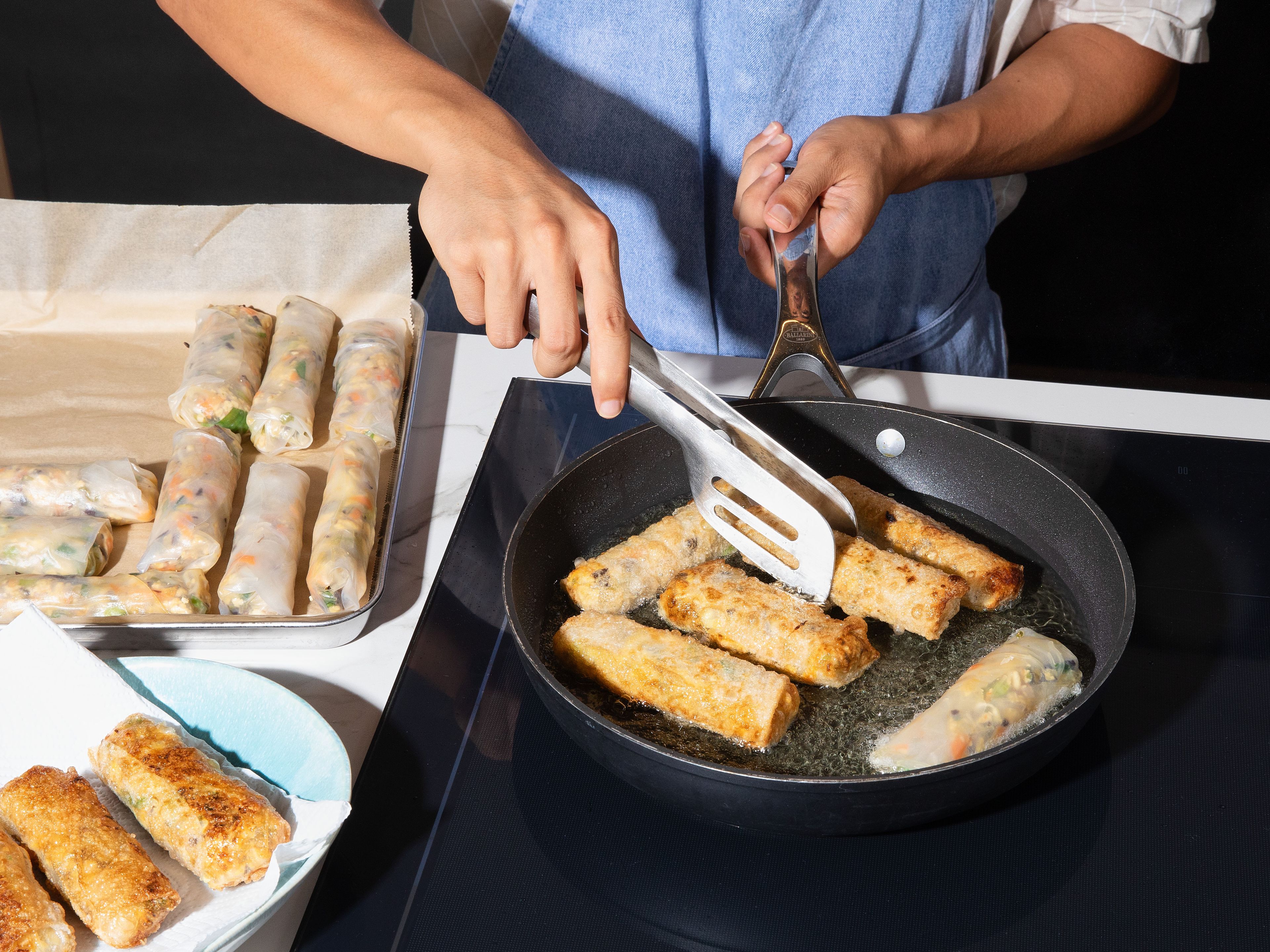 Heat sufficient vegetable oil in a large pan over medium heat. Carefully add spring rolls and fry until golden brown and crispy from all sides. Drain on paper towels and serve with rice noodles, cucumber slices and other sides and dips to your liking.