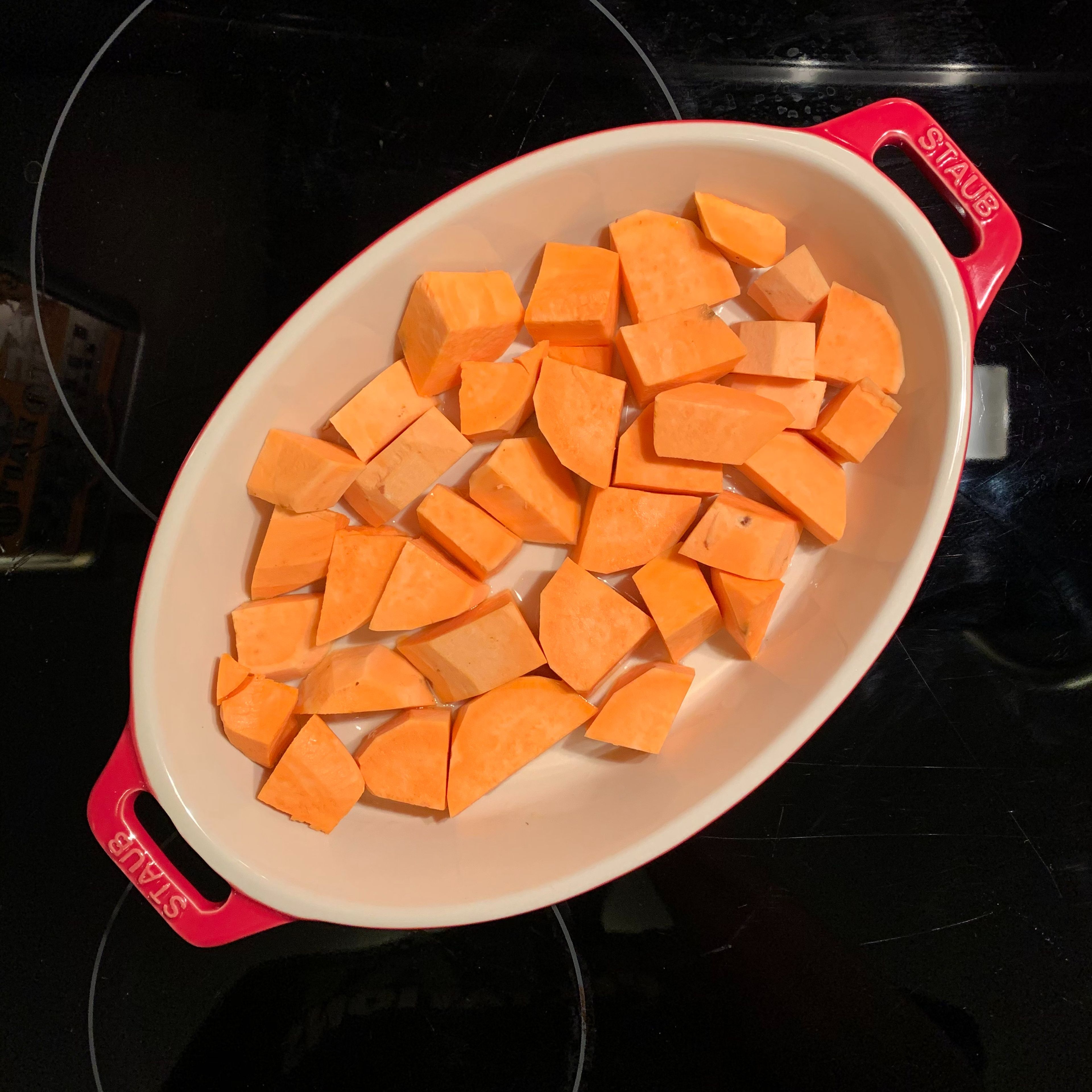 Cover bottom of the au gratin pan in olive oil. Peel sweet potatoes and cut them into pieces slightly larger than bite-sized. Place pieces in pan and cover in olive oil. Salt and pepper to taste.