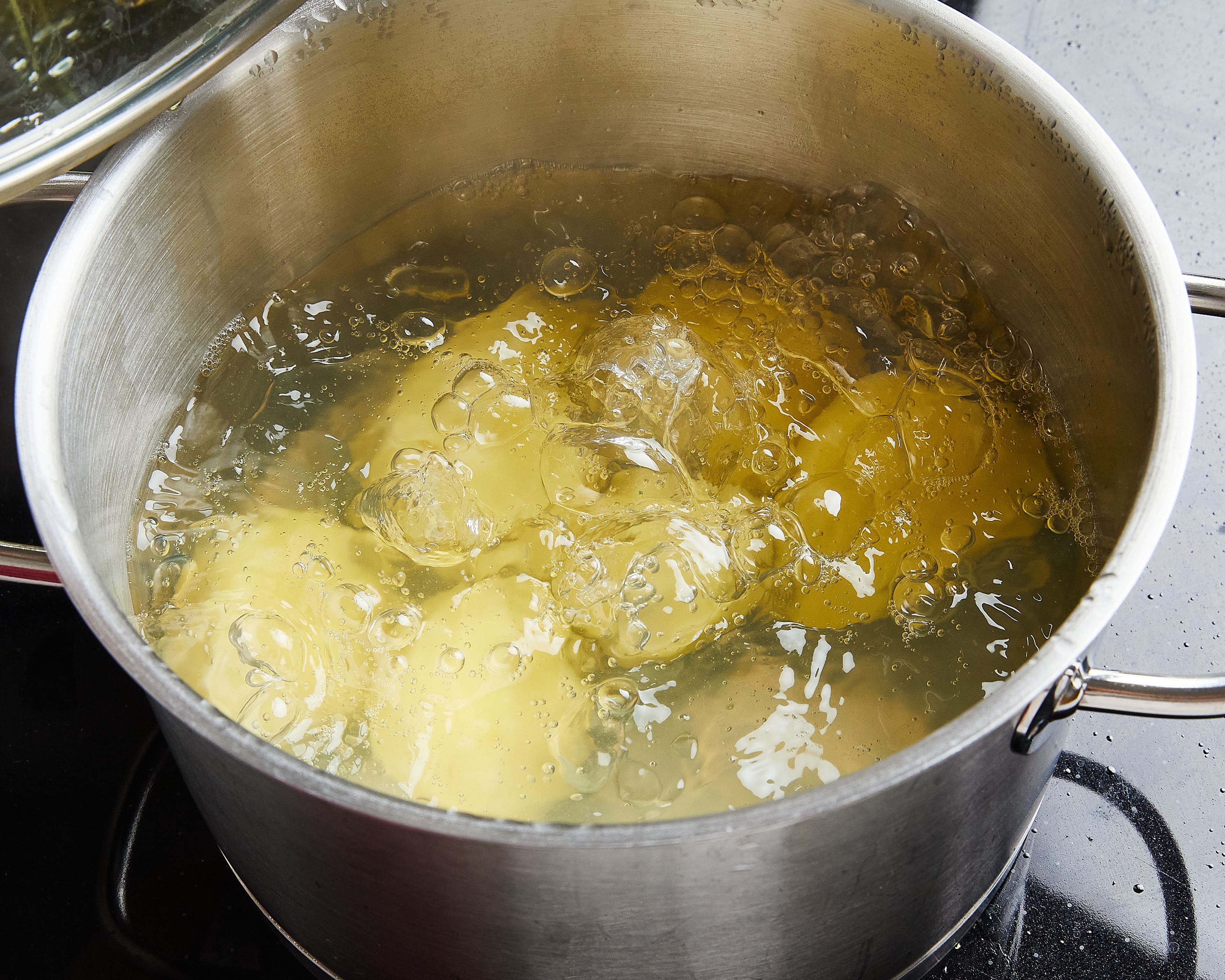 Kartoffeln schälen, längs halbieren und in einen Topf geben. Mit kaltem Wasser auffüllen, ungesalzen aufkochen lassen und ca. 15–20 Min., je nach Größe, kochen, bis sie weich sind.