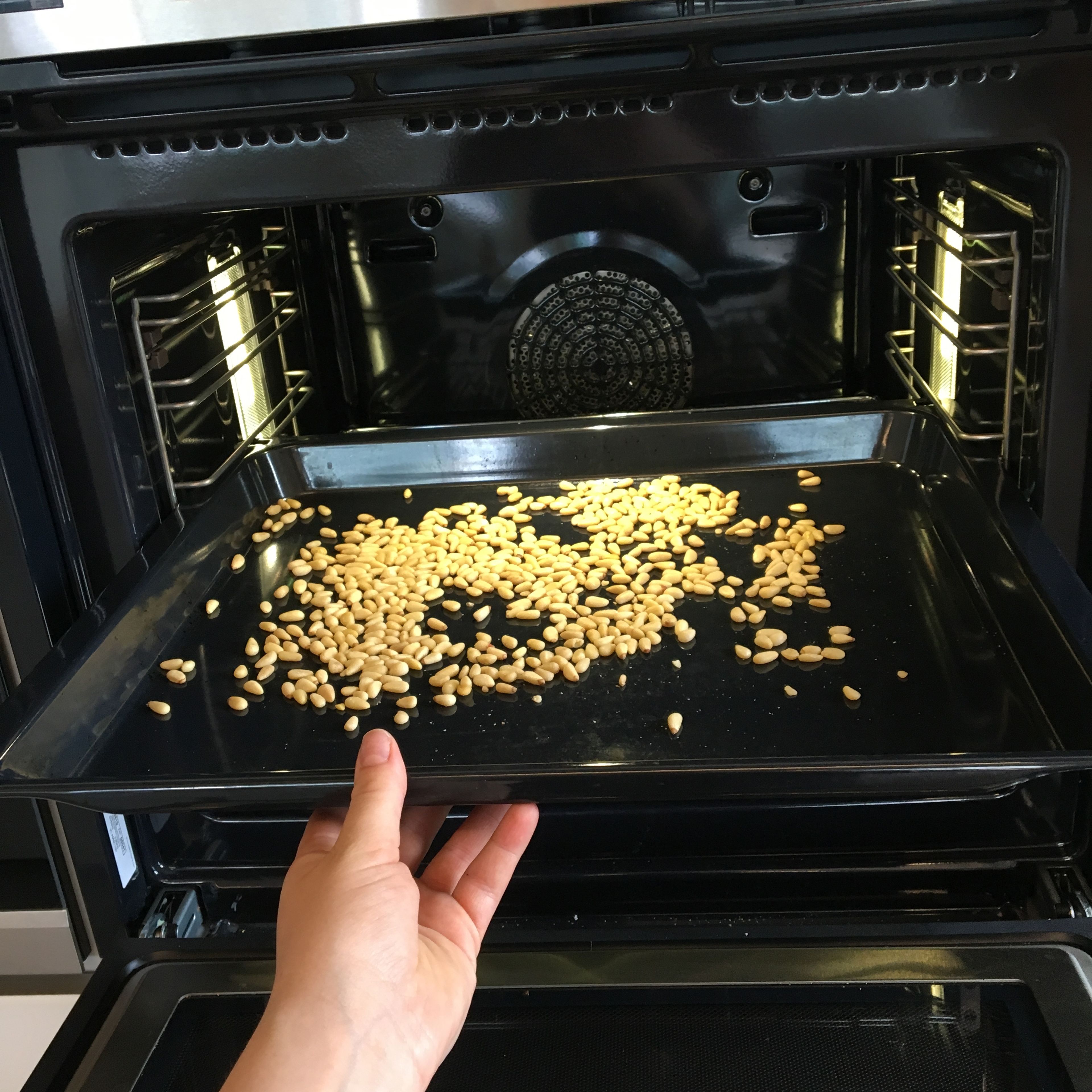 Pinienkerne im vorgeheizten Ofen bei 160 Grad 10 min rösten.