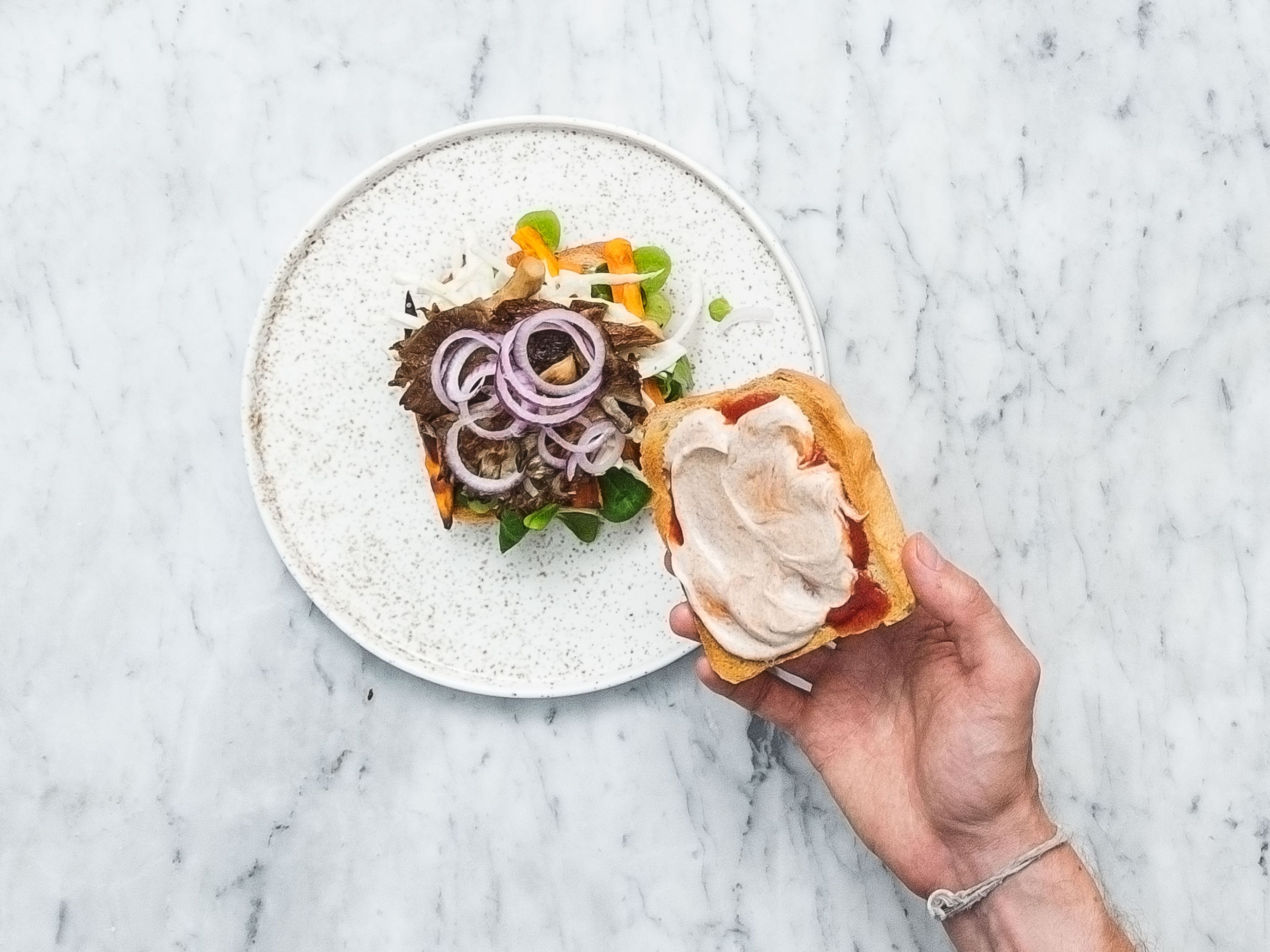 Spread some ketchup and vegan spicy cinnamon mayonnaise on each toasted white bread slice. Top half of the slices with lamb’s lettuce, sweet potato fries, white cabbage slaw, fried oyster mushrooms, and some sliced red onion. Place remaining white bread slices on top. Enjoy!