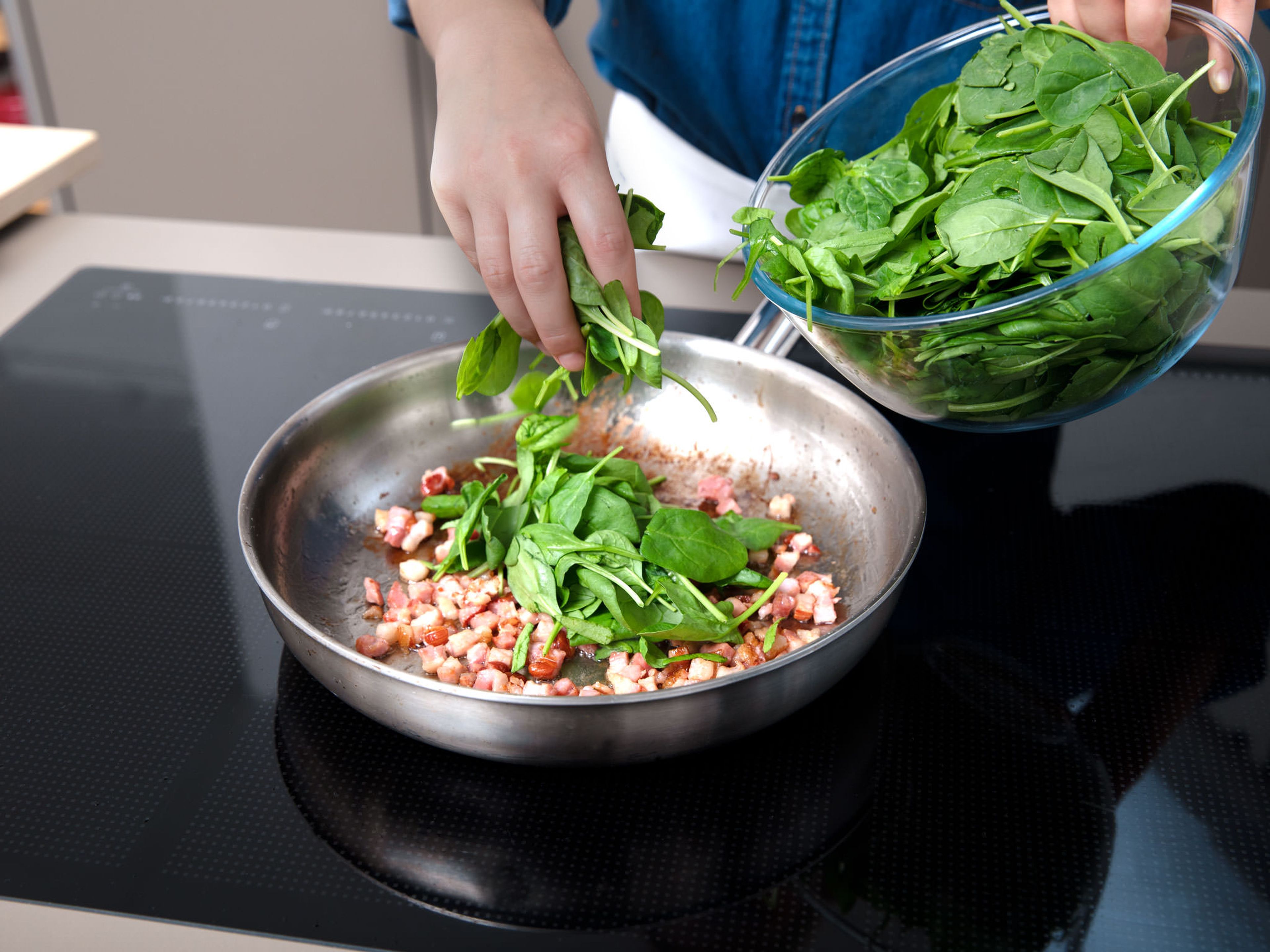 Fry diced smoked bacon in a large frying pan until crispy. Add baby spinach and keep frying until the spinach starts to wilt. Deglaze with half of the lime juice and season with salt and pepper to taste. Remove from heat.
