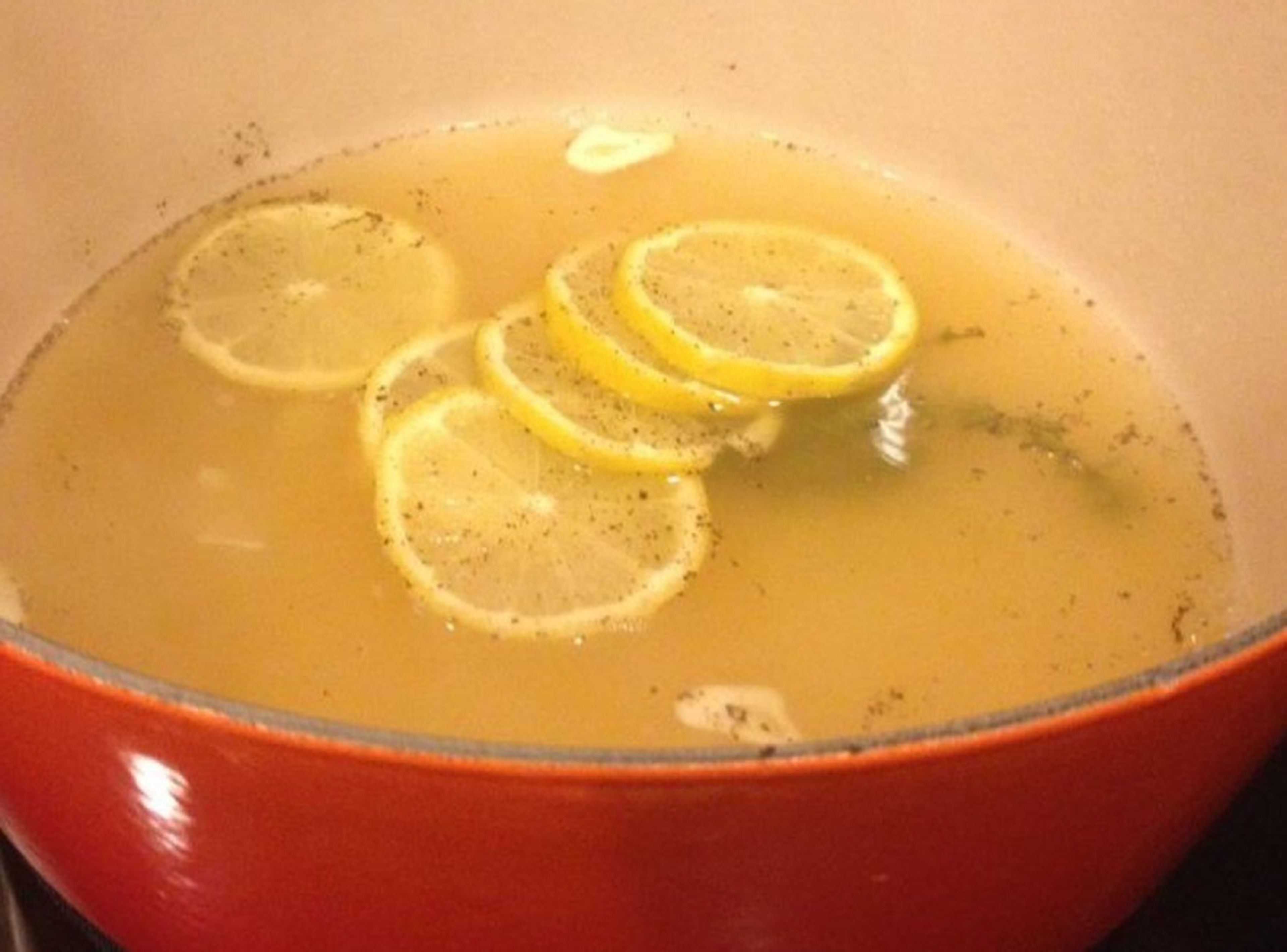 Simmer the broth with pepper, salt, thyme, garlic, and lemon over medium-low heat.