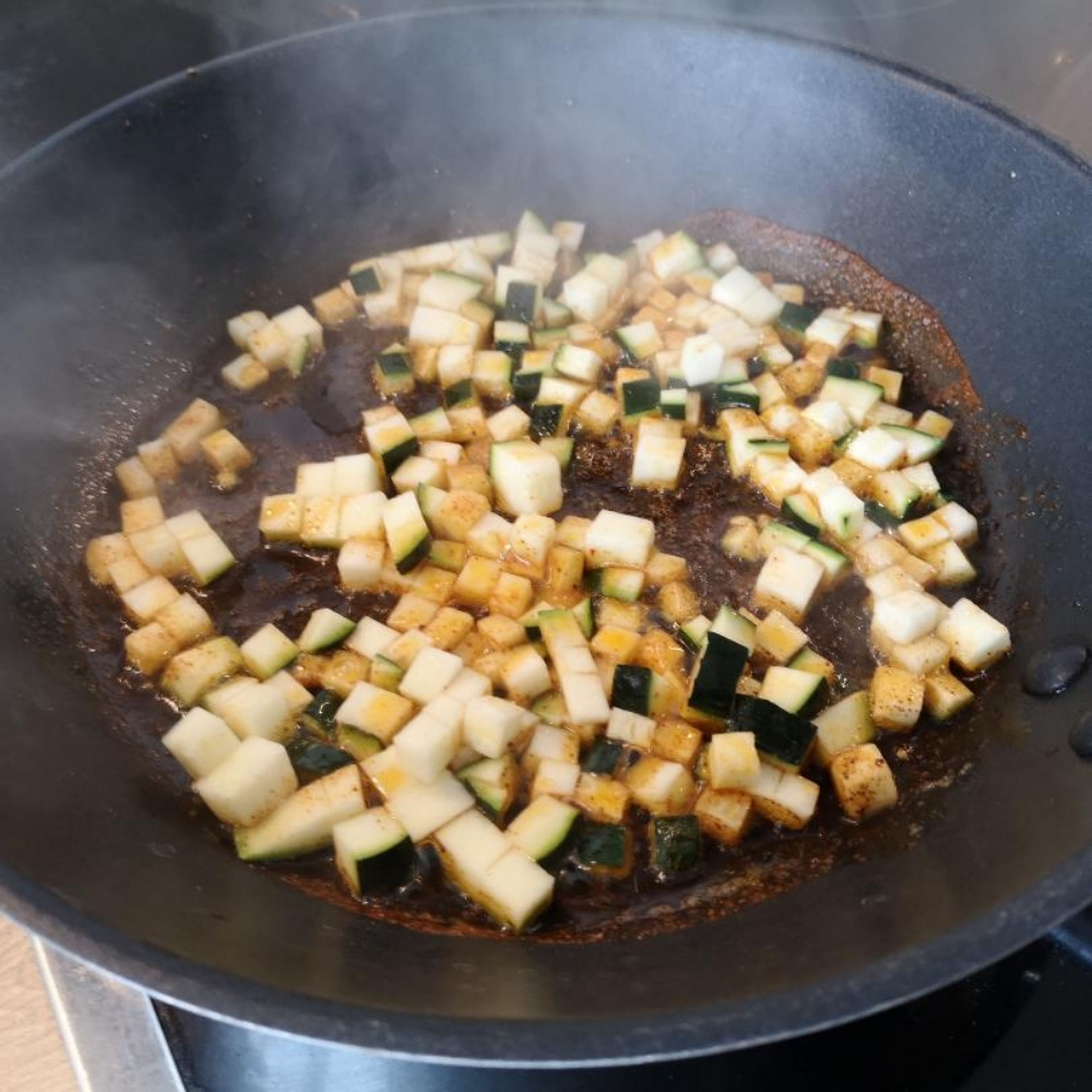 Das Öl in einer Pfanne erhitzen, etwas Paprikapulver hinzufügen, kurz anrösten und dann die Zucchini hinzufügen und durchmischen.