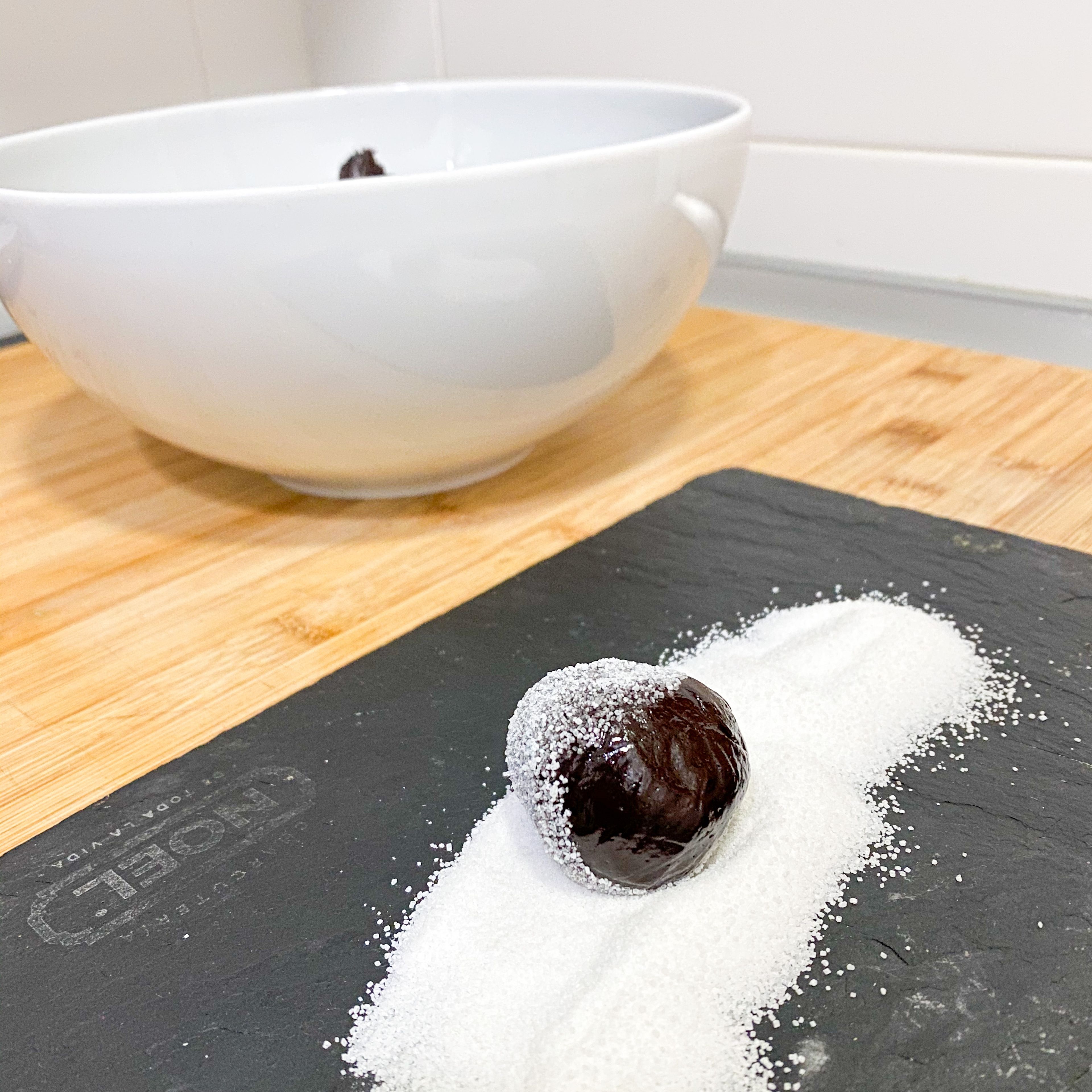 take out of the fridge , knead the dough to release the cold and roll into small balls .then roll the balls over the caster sugar