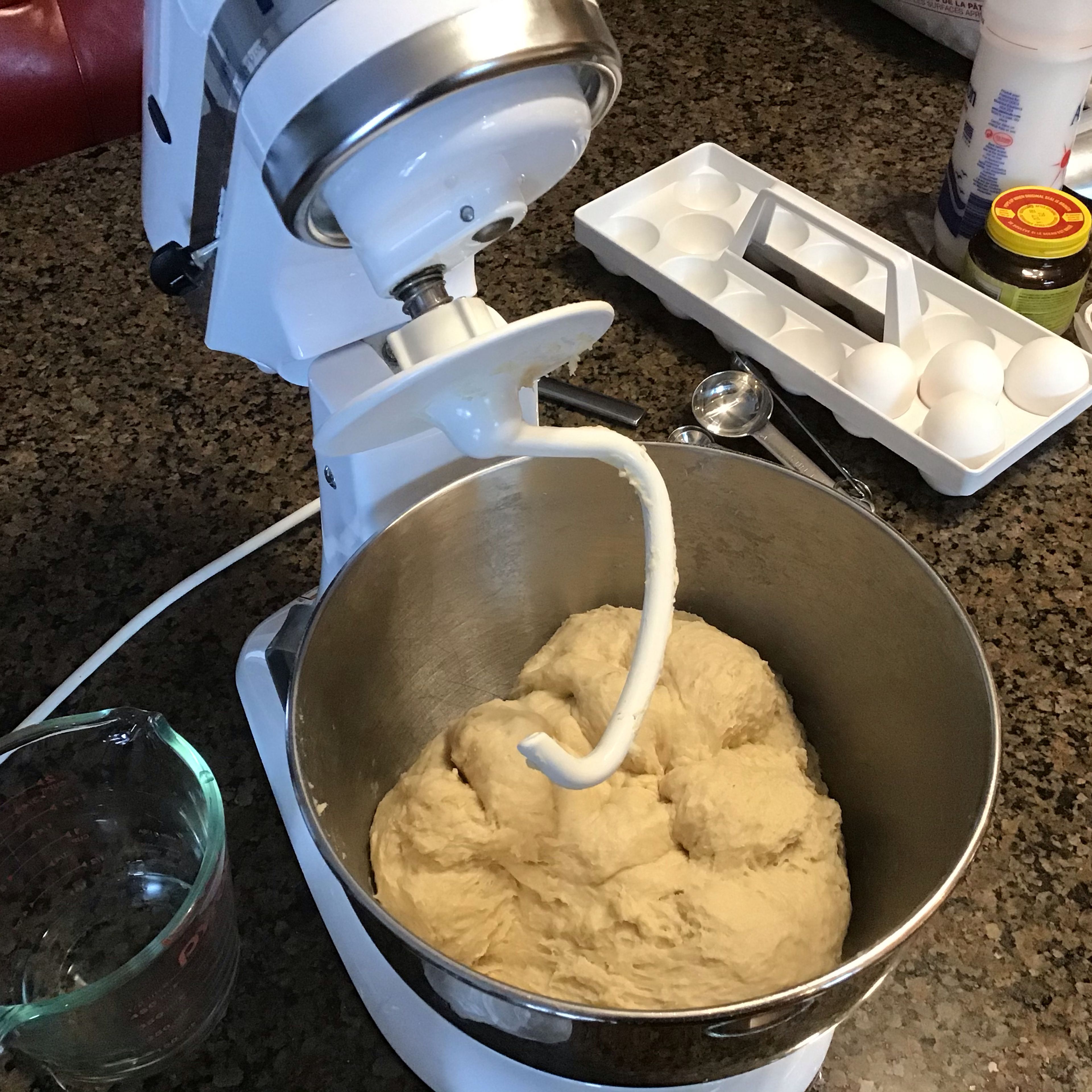 Let mixer run until dough comes together into a soft ball. If dough is not incorporating all of the flour, add 2 or 3 tablespoons of water and continue to run mixer for 3 to 4 minutes, until ball of dough comes together and it has a smooth texture. If dough is too wet and doesn’t form a ball, add 1 - 2 tbsp flour at a time and let each mix in until dough forms and comes away from sides of mixing bowl.