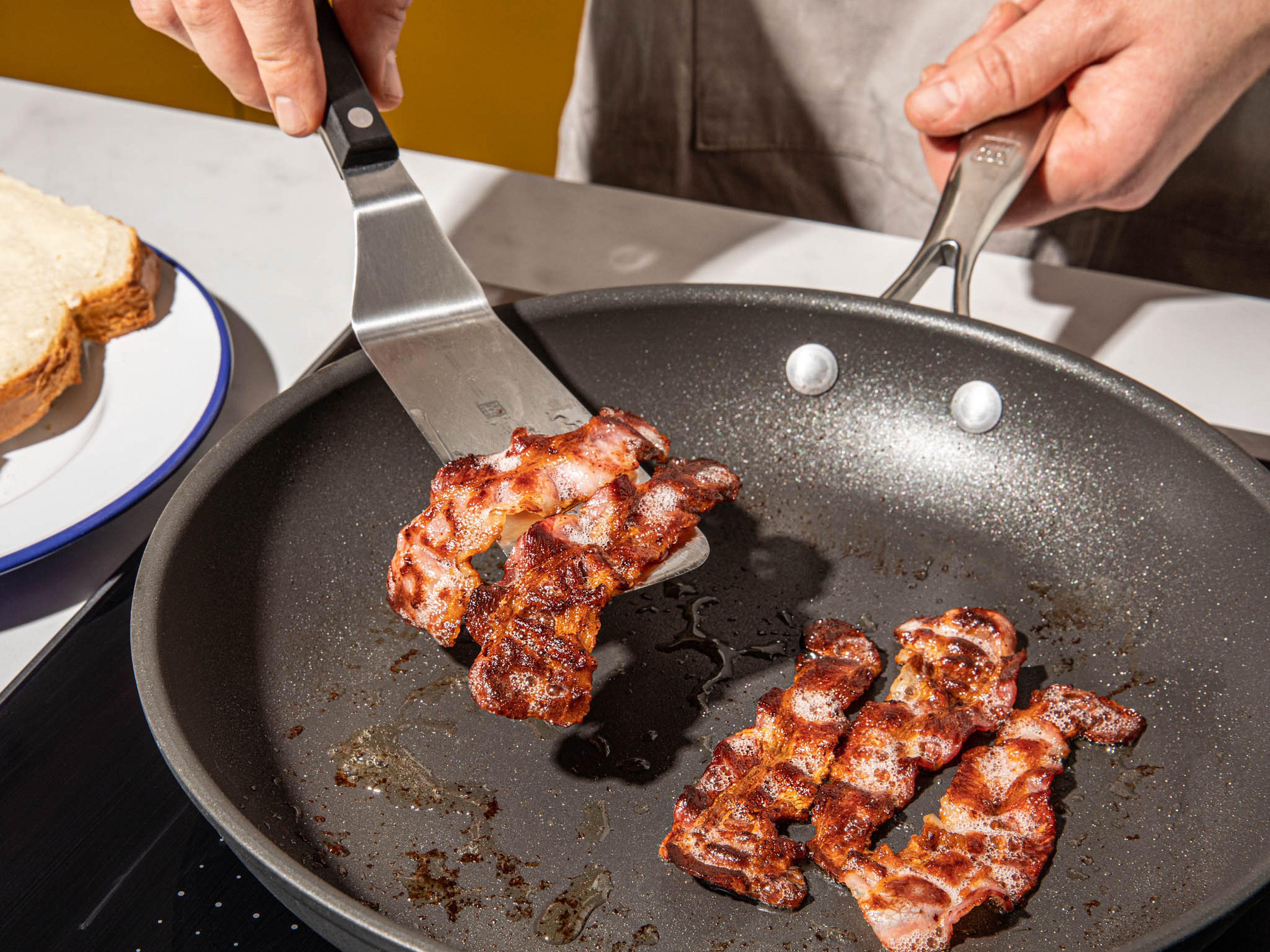 Add bacon strips to a frying pan over medium-high heat. Fry until crispy on both sides, approx. 2-3 min.