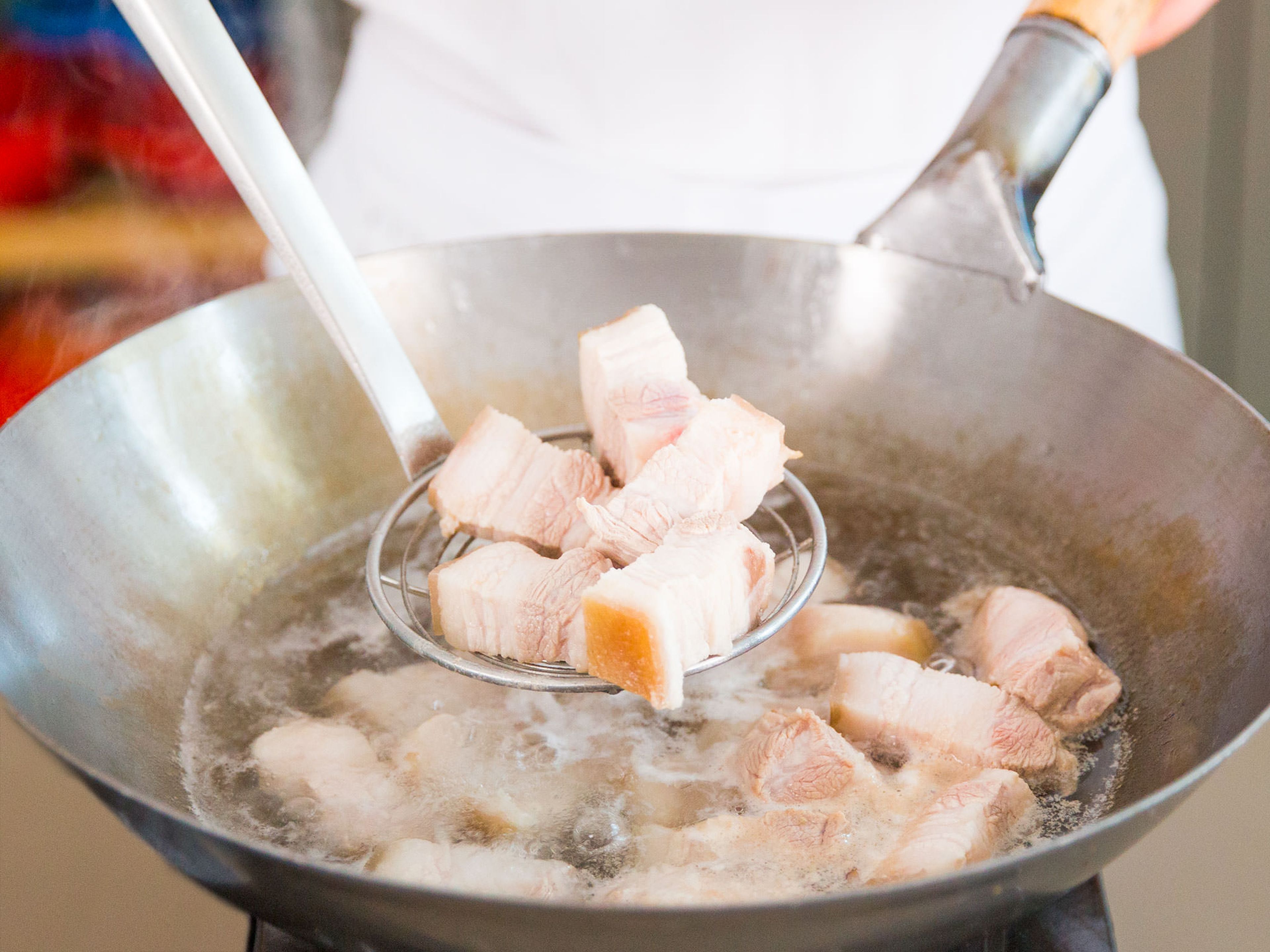 Fill wok one third of the way full with hot water. Place pork belly in water, bring to a boil, and cook for approx. 5 – 7 min. Strain and set aside.