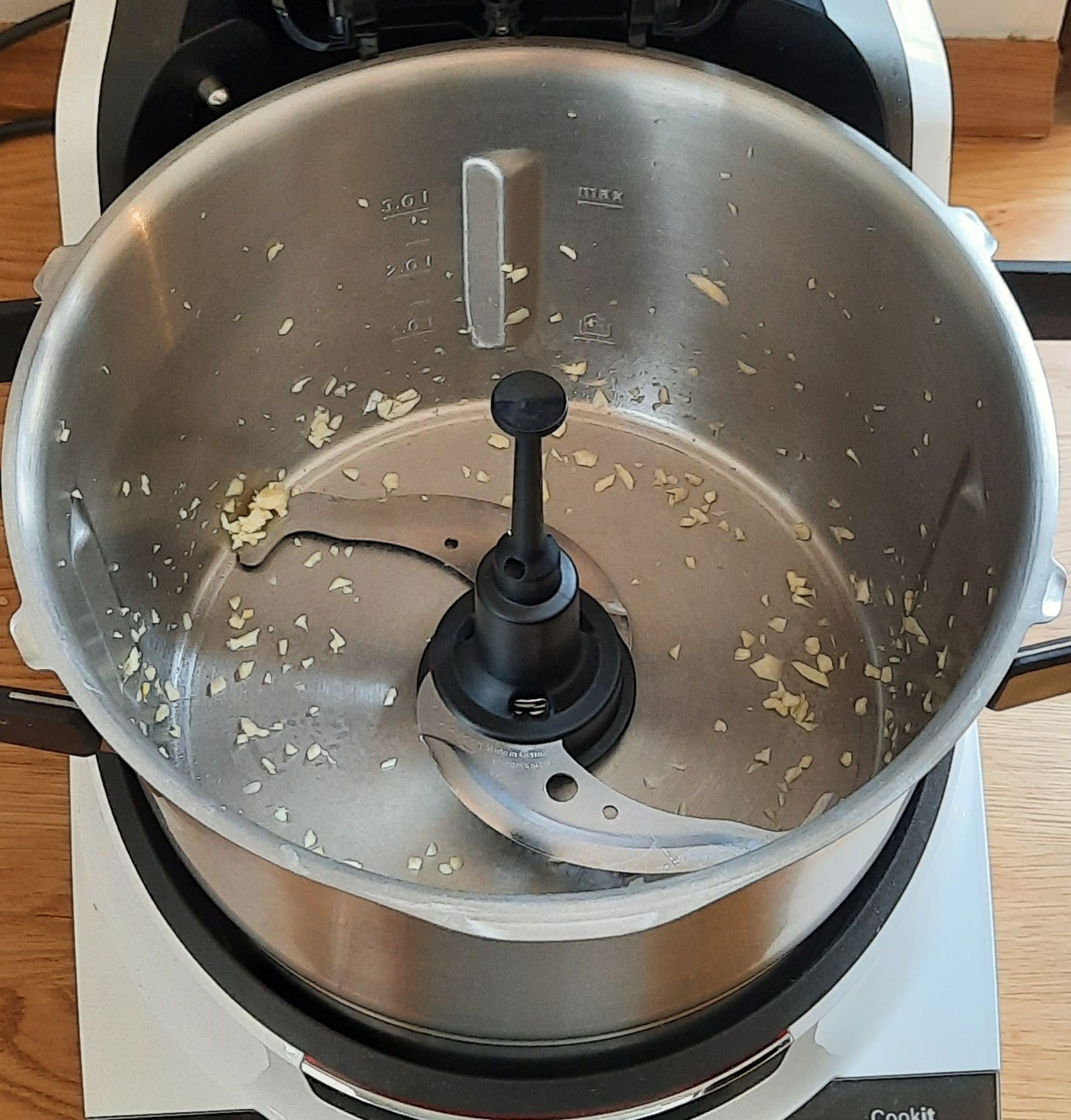 Das Universalmesser in den Cookit einsetzen. Die beiden Knoblauchzehen schälen und bei geschlossenem Deckel mit eingesetztem Messbecher zerkleinern (Universalmesser | Stufe 14 | 15 Sekunden). Das Universalmesser entfernen.