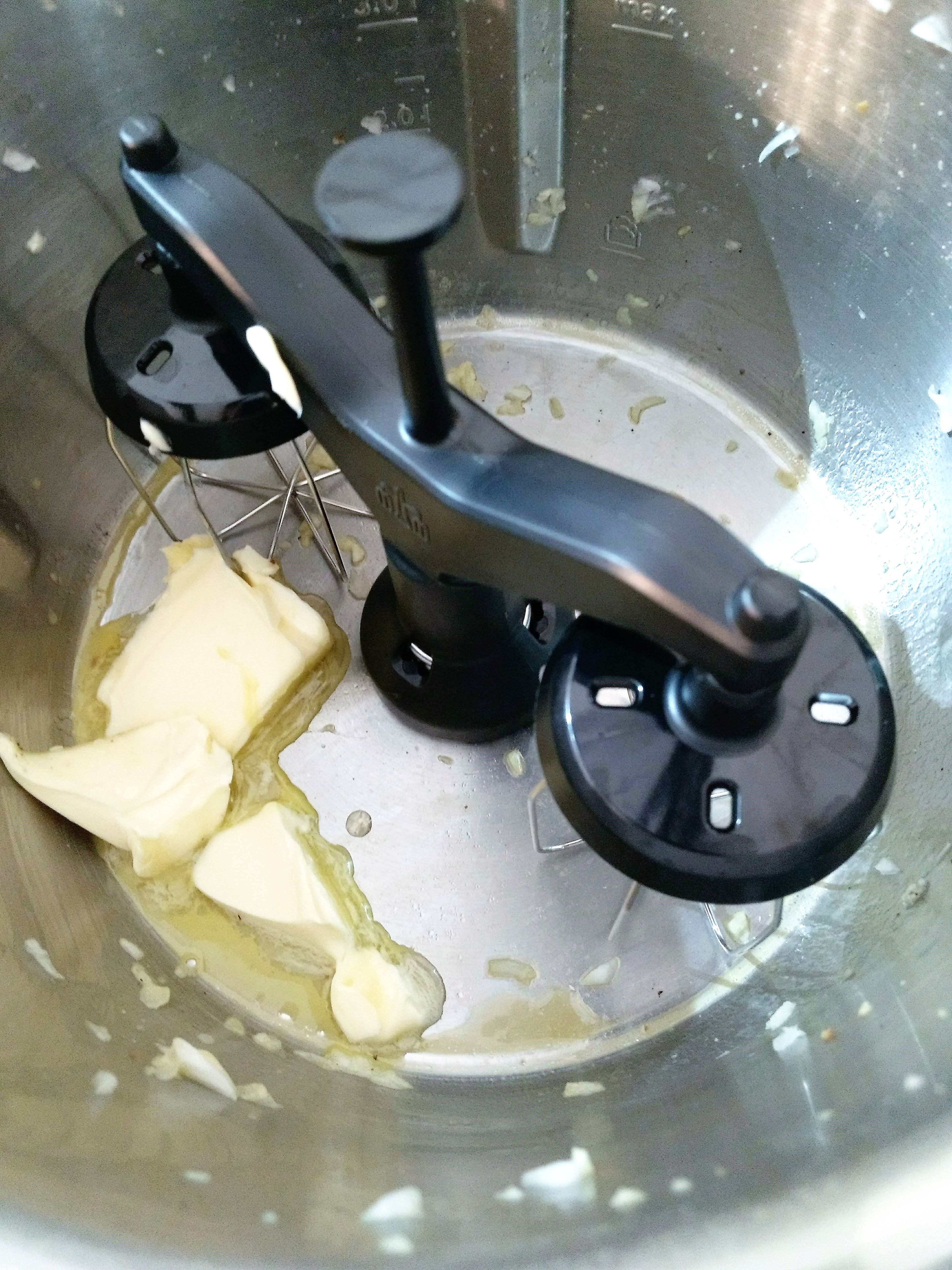 Zwillings-Rührbesen einsetzen. Butter in Topf einwiegen. Den beiseite gelegten 1 TL gehackten Knoblauch hinzufügen. Deckel ohne Messbecher schließen und die Butter zerlaufen lassen (Zwillings-Rührbesen | Stufe 1 | 130°C | 2 Min.). Mehl einwiegen, den Deckel ohne Messbecher schließen und das Mehl anschwitzen (Zwillings-Rührbesen | Stufe 3 | 130°C | 3 Min.).