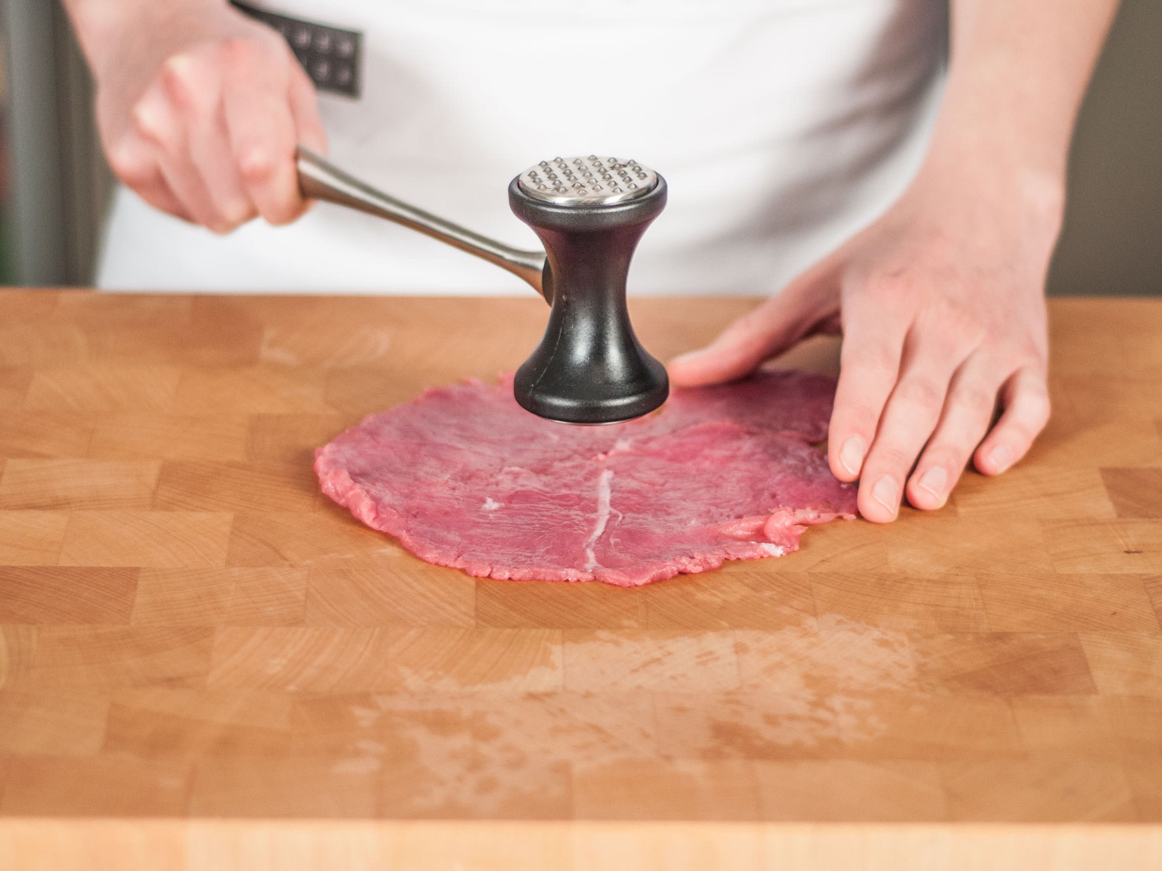 Das Kalbfleisch so dünn wie möglich plattieren, ohne dass Löcher entstehen.