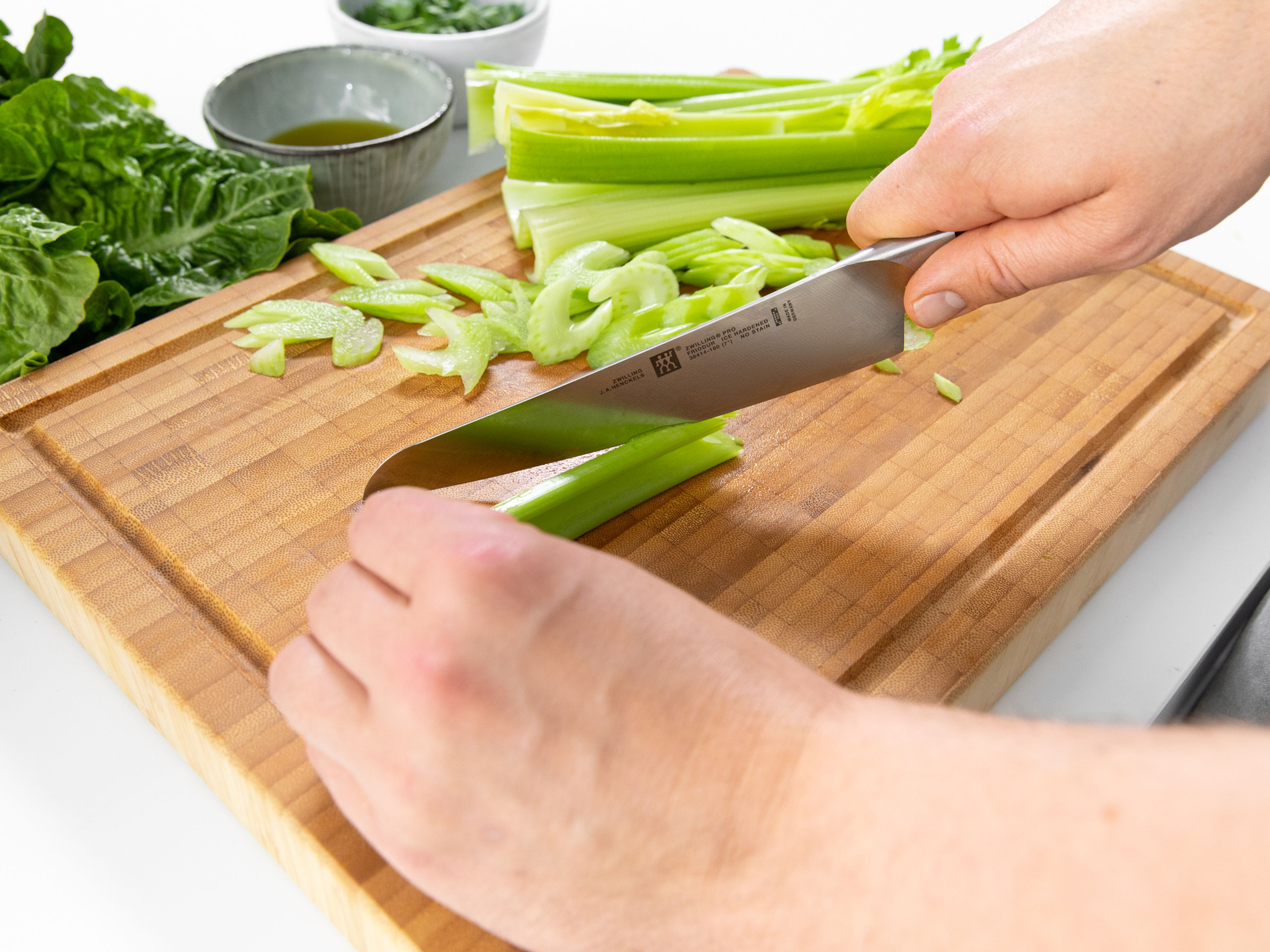 Thinly slice celery with a mandolin, or slice into cubes with a knife. Peel and cube the apples. Slice lettuce into strips. Peel and slice orange into segments.