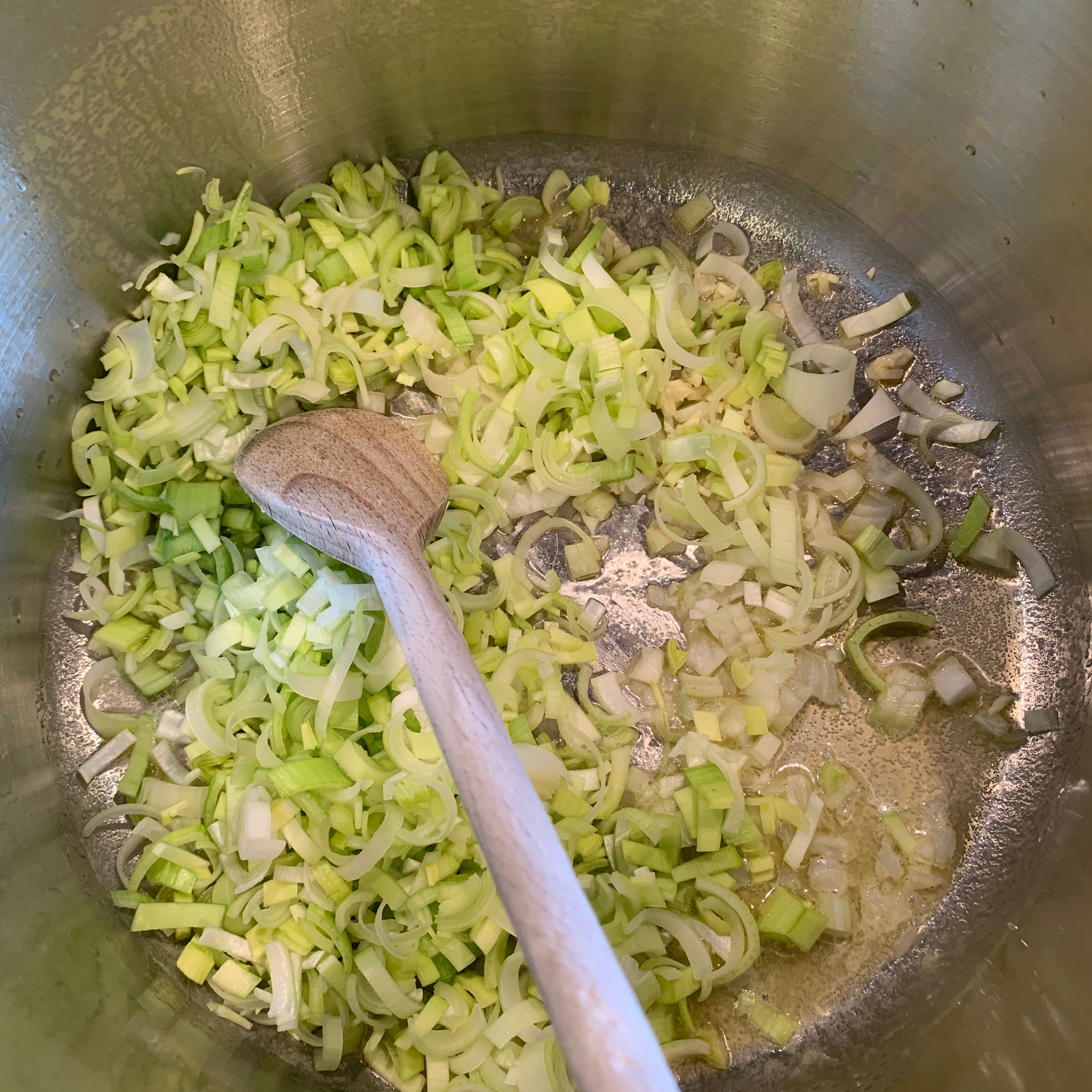 Butter und Olivenöl in einem großen Topf erhitzen. Lauch, Zwiebeln und Knoblauch hinzugeben und anschwitzen. Mit Salz und Pfeffer würzen