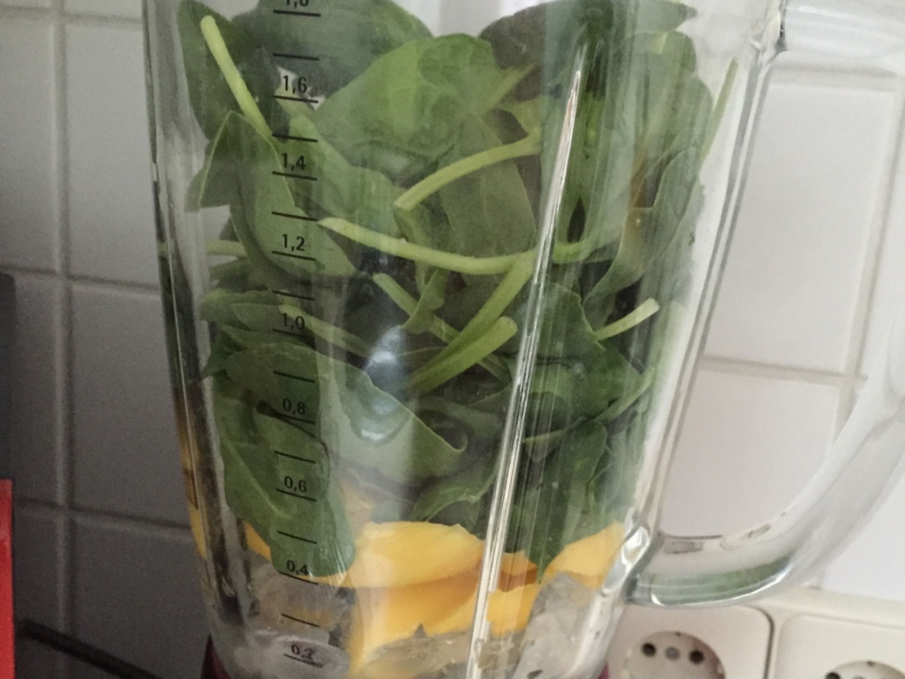Chop mango. Fill blender with ice cubes, followed by mango, and baby spinach.