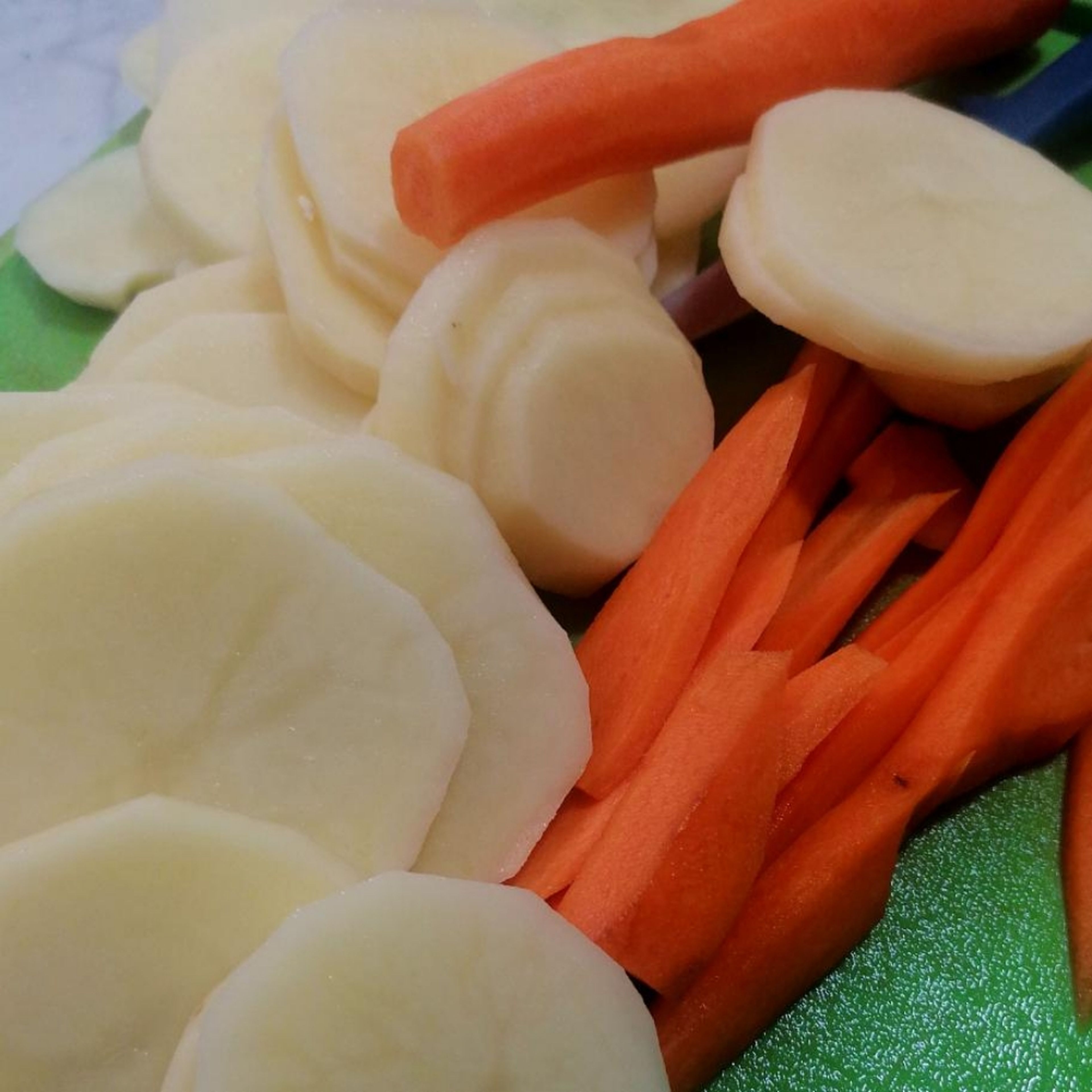 Cut the potatoes, carrots, tomato, bell pepper and onion into fine slices.