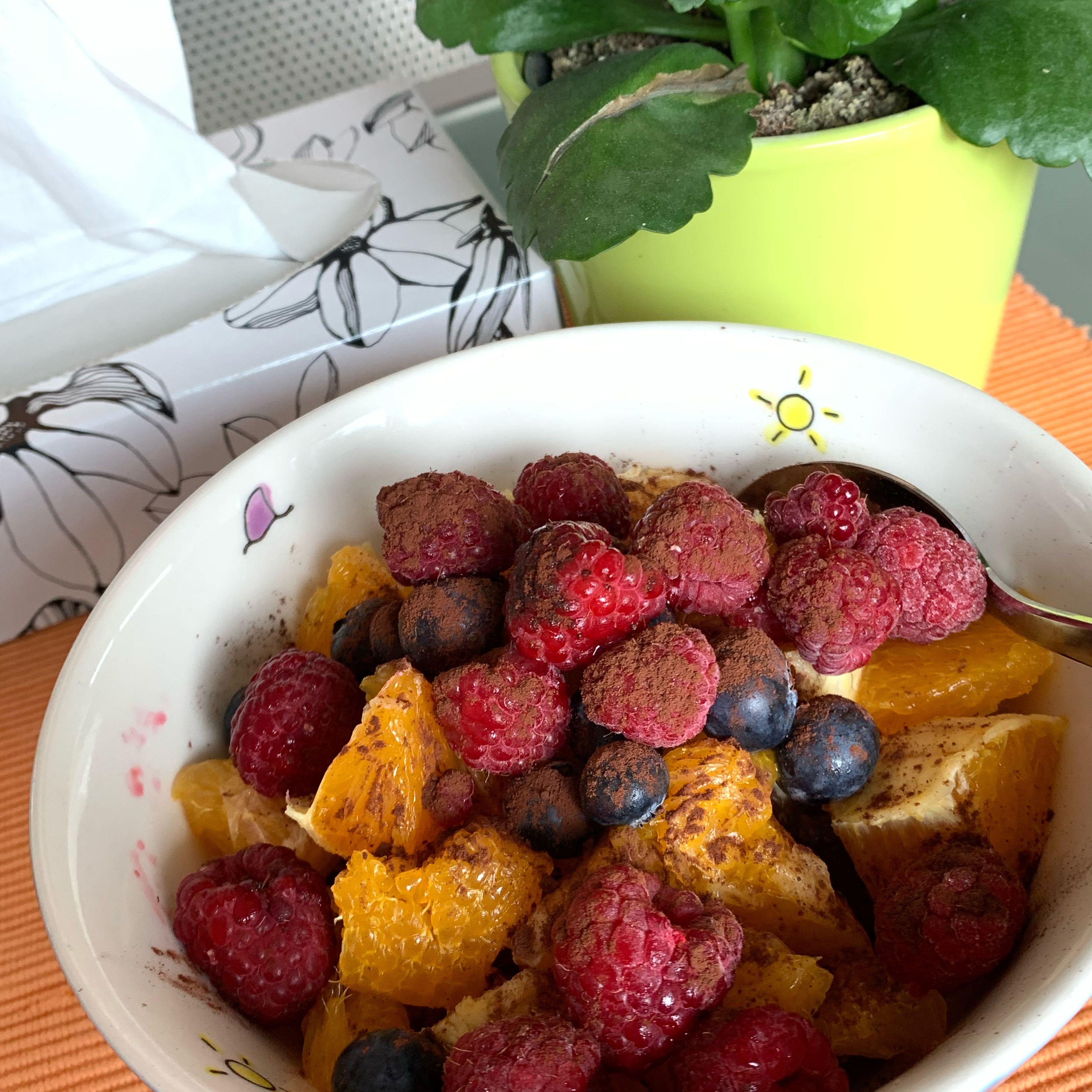 Fülle das Porridge in eine Müslischale, toppe es mit der Orange und den Beeren, streue die Schokodrops darauf und bestäube das ganze mit ein wenig Kakaopulver. Ta-daaa! Guten Appetit!