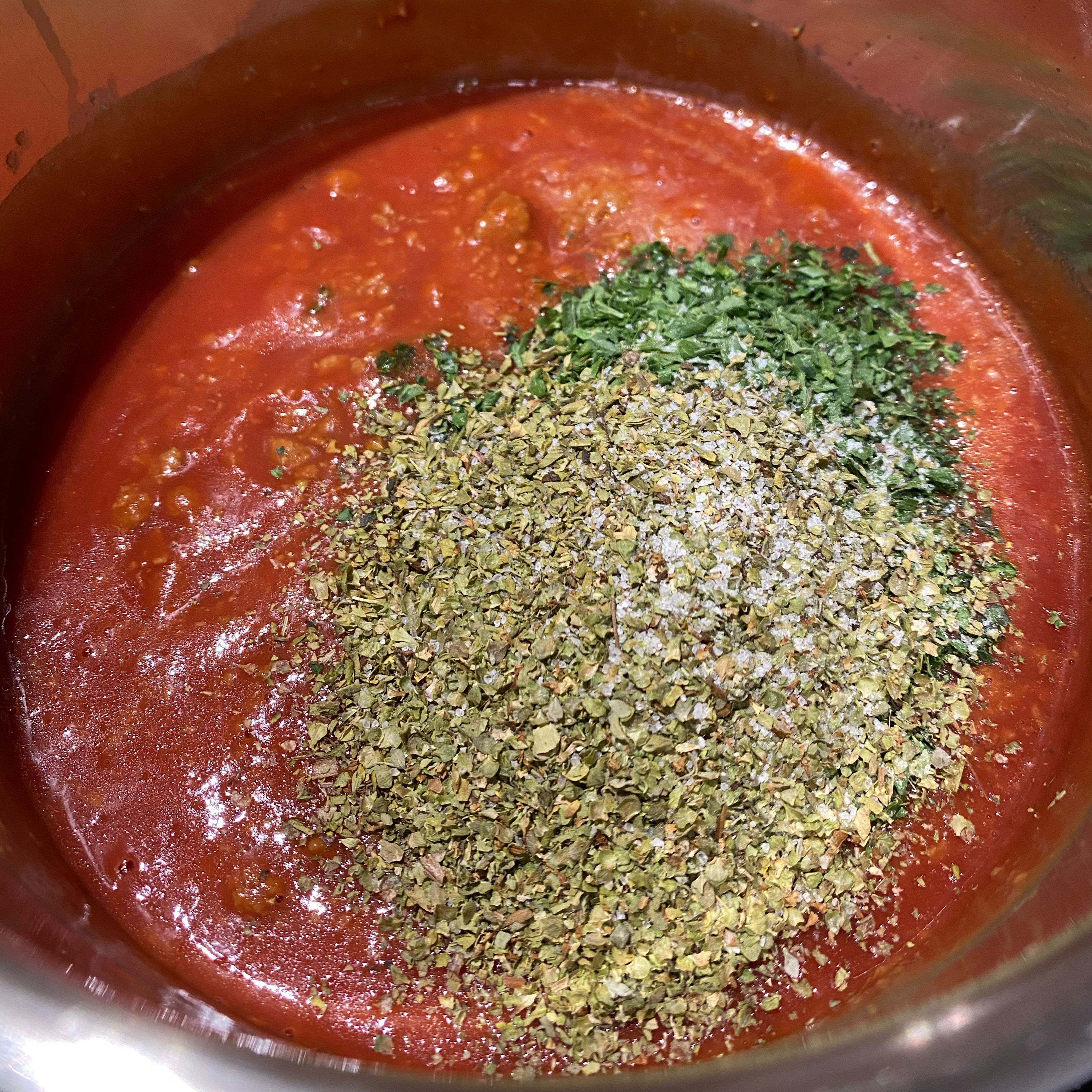 Die Tomatensoße hinzugeben. Das Salz und die Gewürzen hinzugeben und abschmecken.