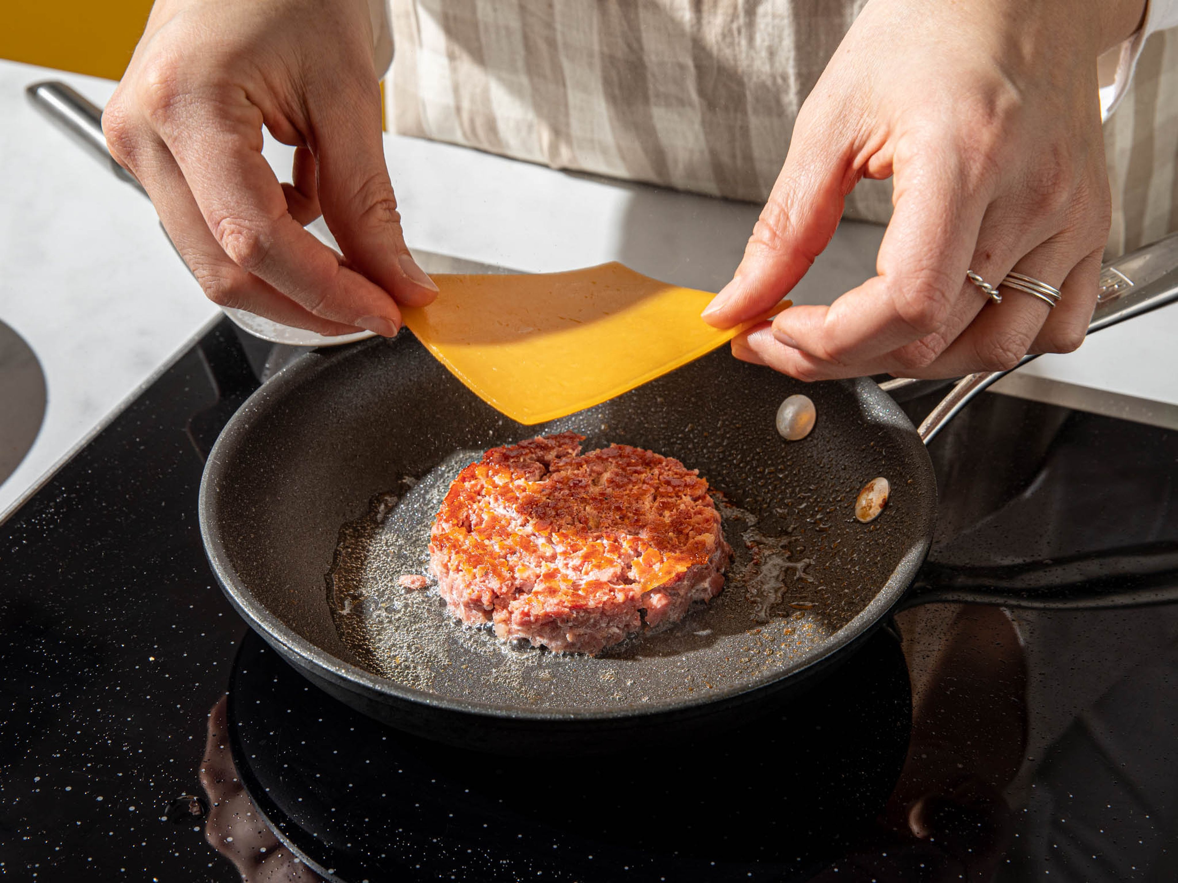Preheat the oven to a ‘keep warm’ setting. Remove Italian sausage meat from casing. Use your fingers to crumble the meat until fine, with no large clumps, and press very tightly into an egg ring to create a patty—you can also make your own ring using aluminium foil. Heat a frying pan over high heat. Once the pan is hot, carefully add the sausage patty (still in the ring). Fry for approx. 3-4 min, or until well-browned. Carefully flip it over, remove the ring, and place a slice of cheddar on top to melt. Continue to fry for another 3 min., until the cheese is very melted and the patty browned. Transfer to a plate and place in the warmed oven. Don’t wash up the pan, you'll use the residual fat in the next step.