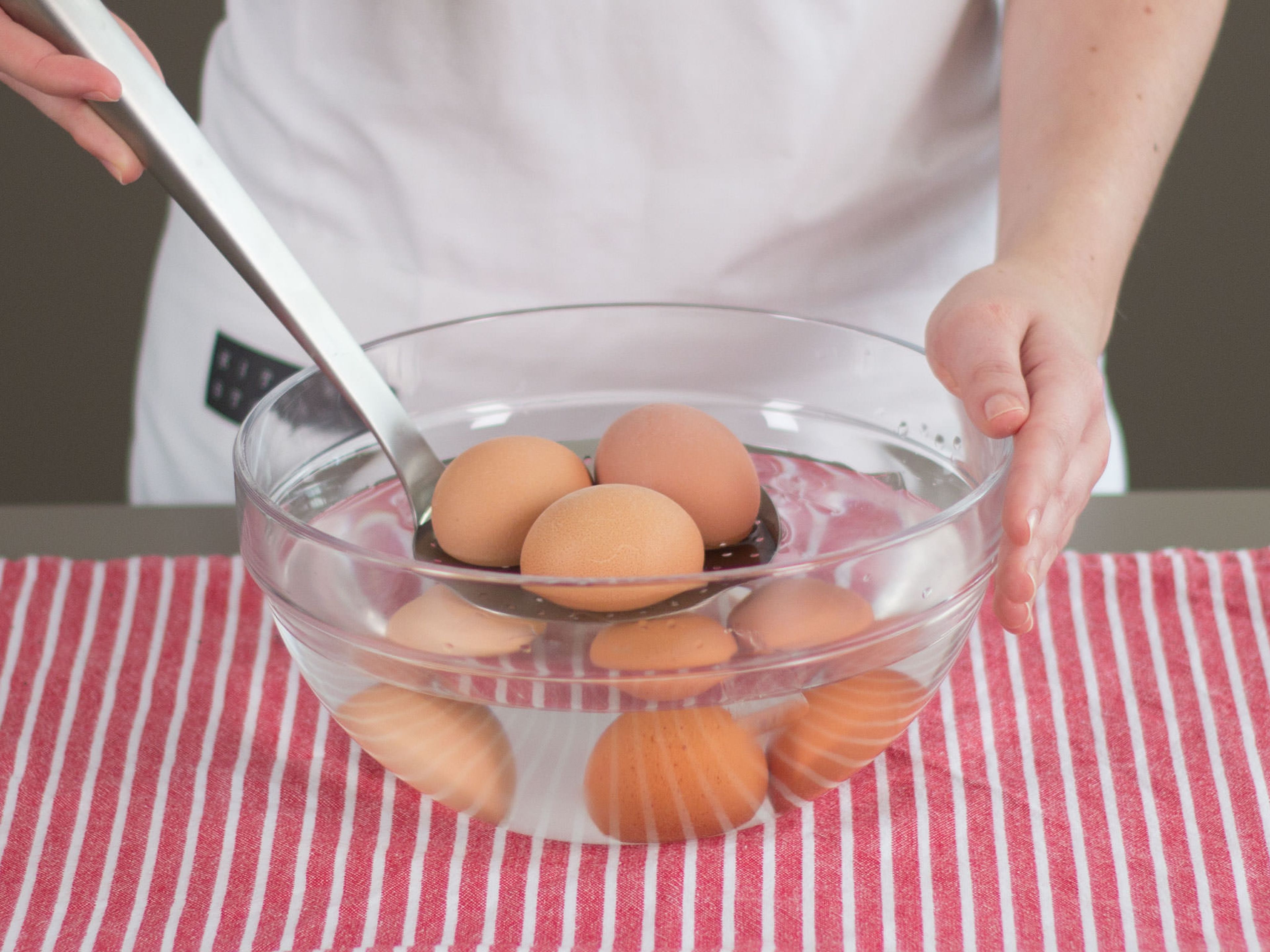 Eier in einer Schüssel mit kaltem Wasser abschrecken.