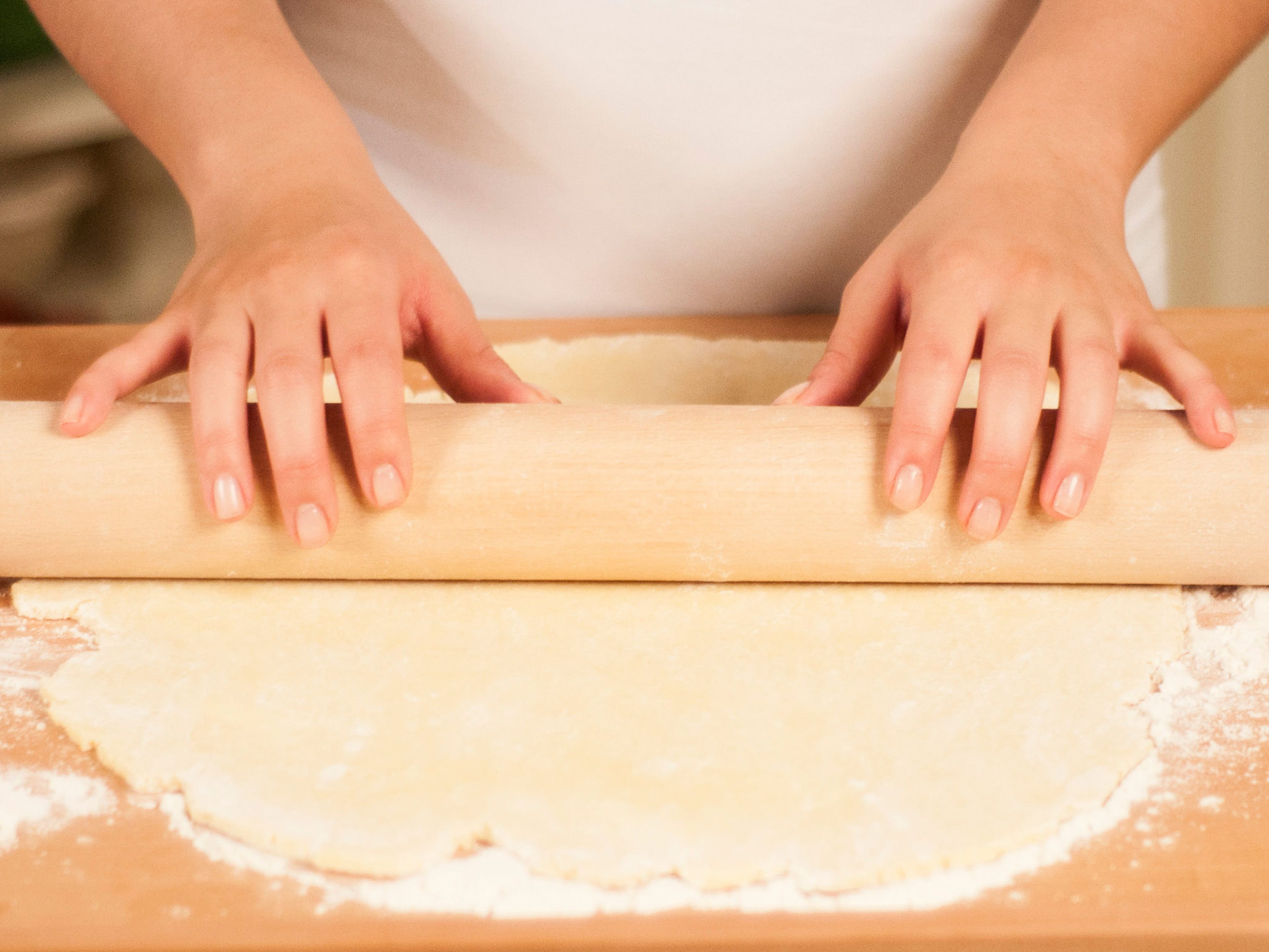With a rolling pin, roll the dough into a round that is a little larger than the tart tin. Work on a floured surface and turn the dough a couple of times to prevent sticking.