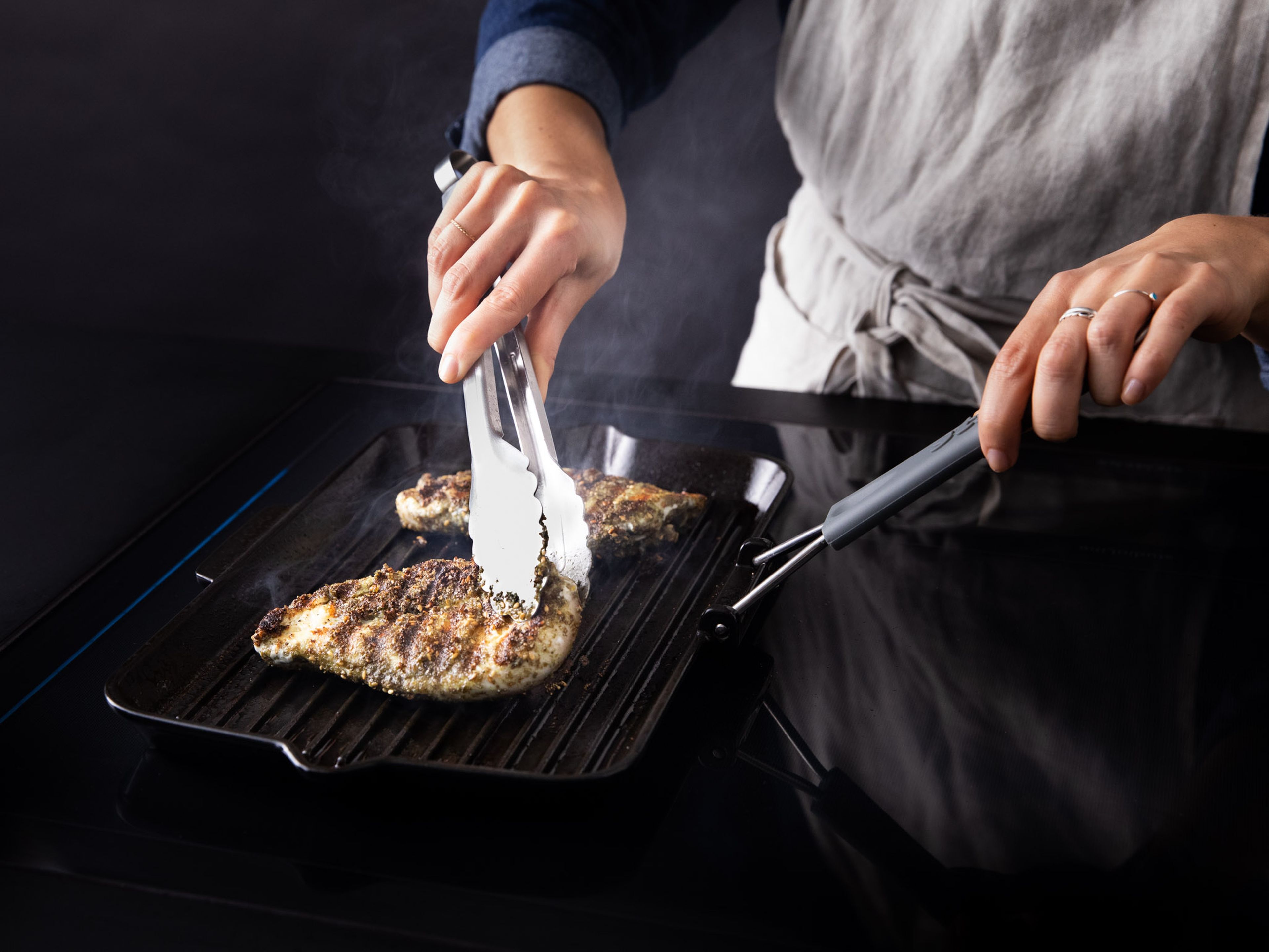 Öl in eine Grillpfanne geben und erhitzen, Hähnchenbrustfilets dazugeben und ca. 5 – 8 Min. von jeder Seite anbraten, bis das Fleisch gar ist. Das Fleisch zur Seite legen und in Folie einwickeln, während du die Gurkenjoghurtsoße vorbereitest.