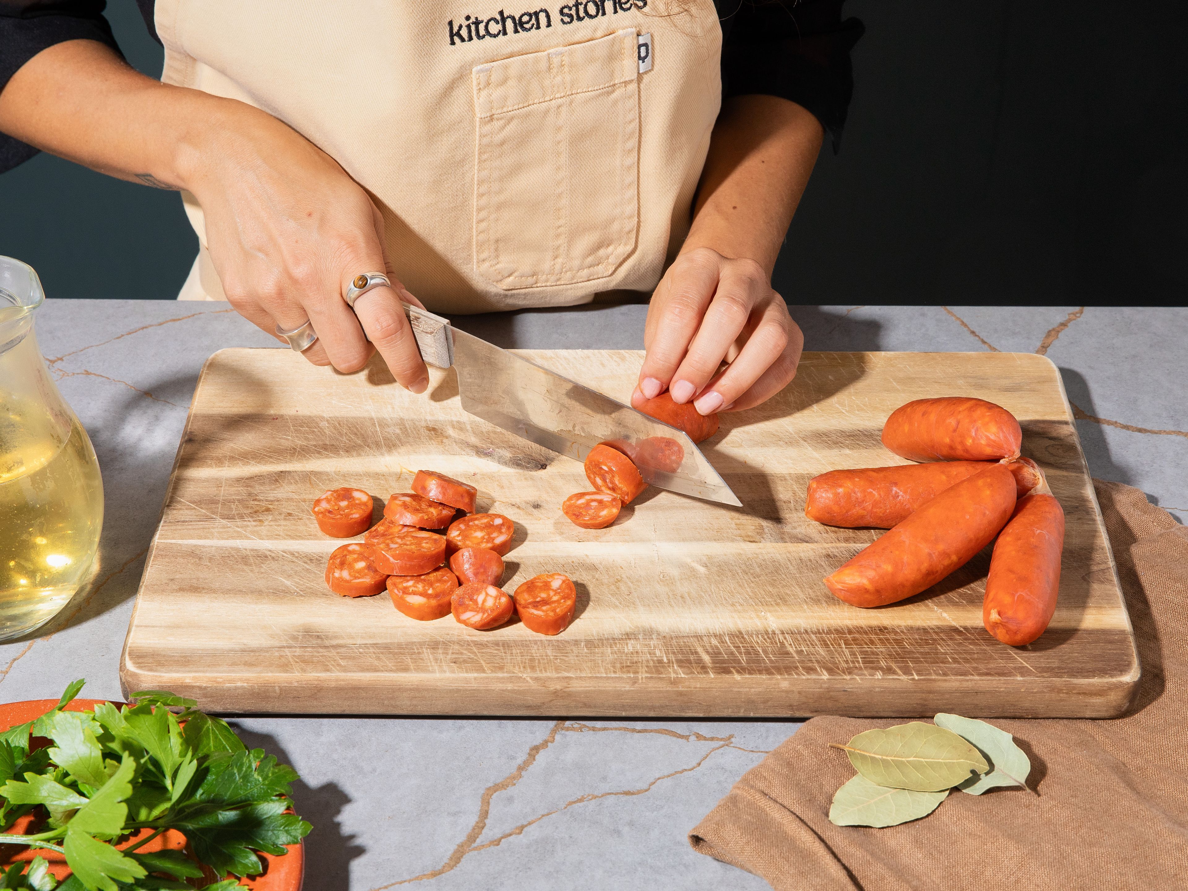 Olivenöl in einer Pfanne auf mittlerer bis hoher Hitze erhitzen. Chorizo in ca. 1 cm dicke Scheiben schneiden und im heißen Öl ca. 3–4 Min. pro Seite anbraten, bis sie an den Rändern dunkle Stellen bekommt.