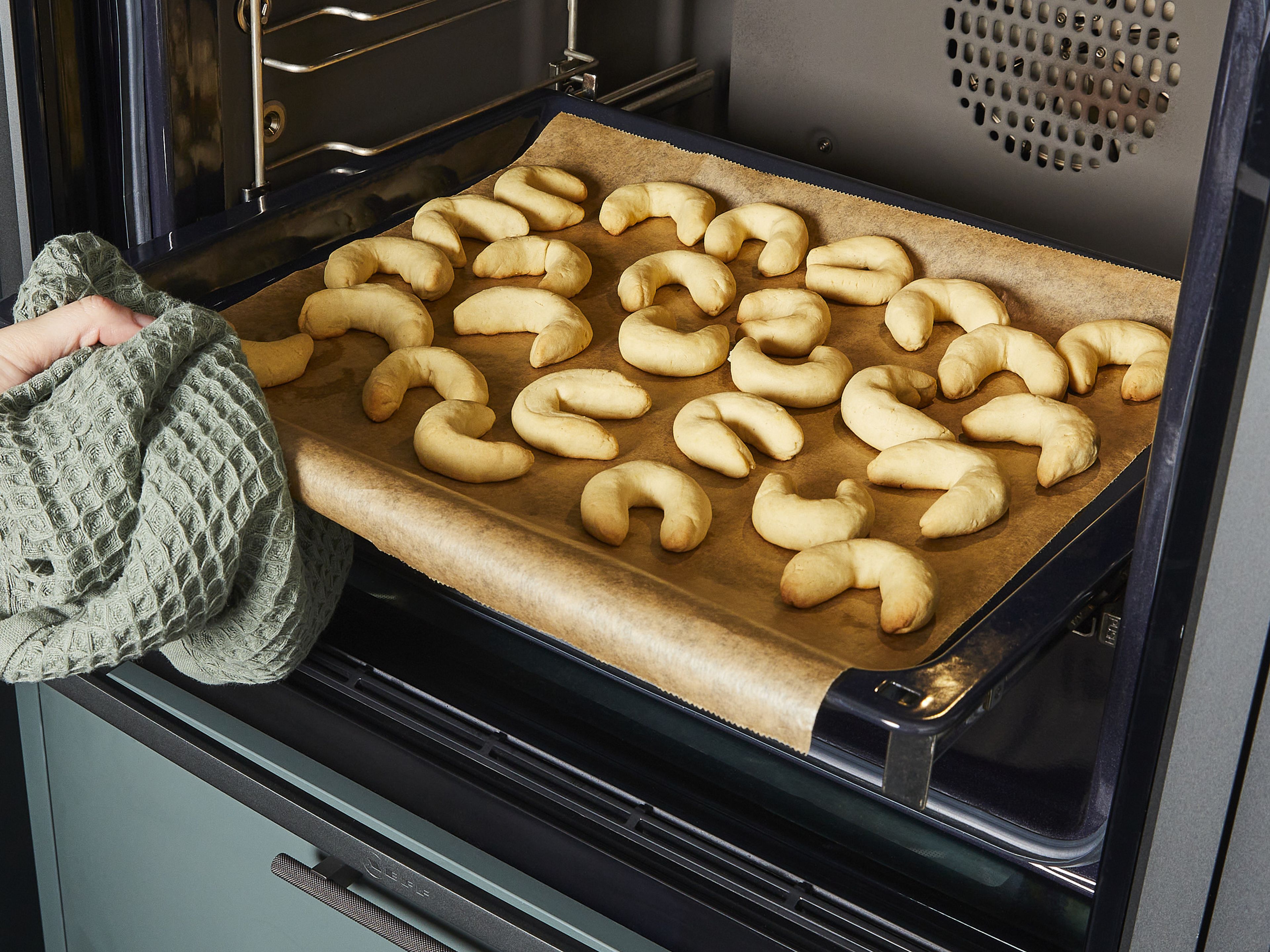 After resting, roll about 1 tbsp of dough into thick, crescent-shaped snakes with your hands and carefully pinch the ends together. Place on a baking sheet lined with parchment paper and bake for approx. 10–12 min.