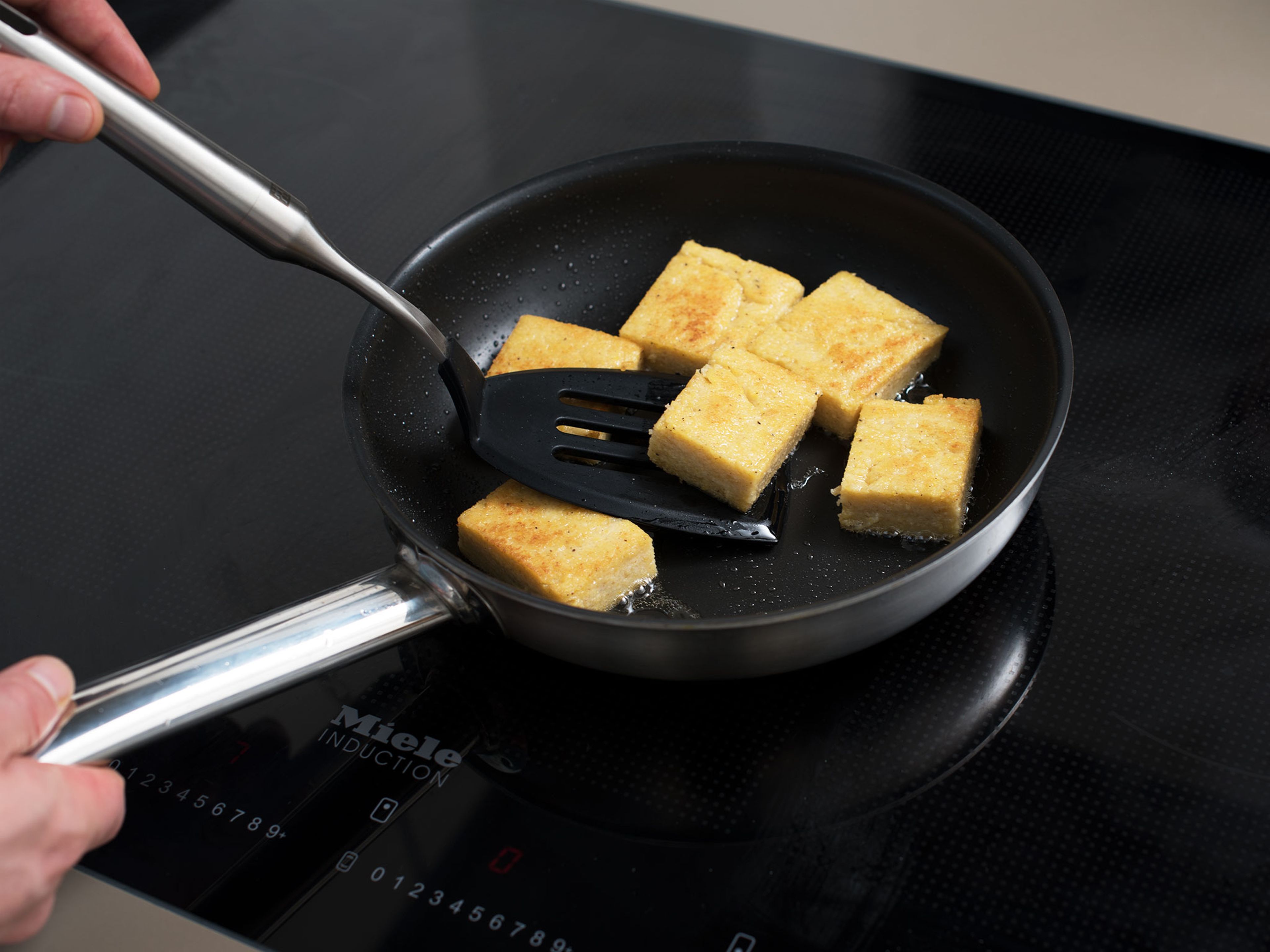 Remove polenta from the fridge. Cut off the edges, then cut polenta into 3x4-cm/ 1x1.5-in. pieces.
Heat oil in a frying pan and fry polenta for approx. 2 min., or until golden brown on both sides.