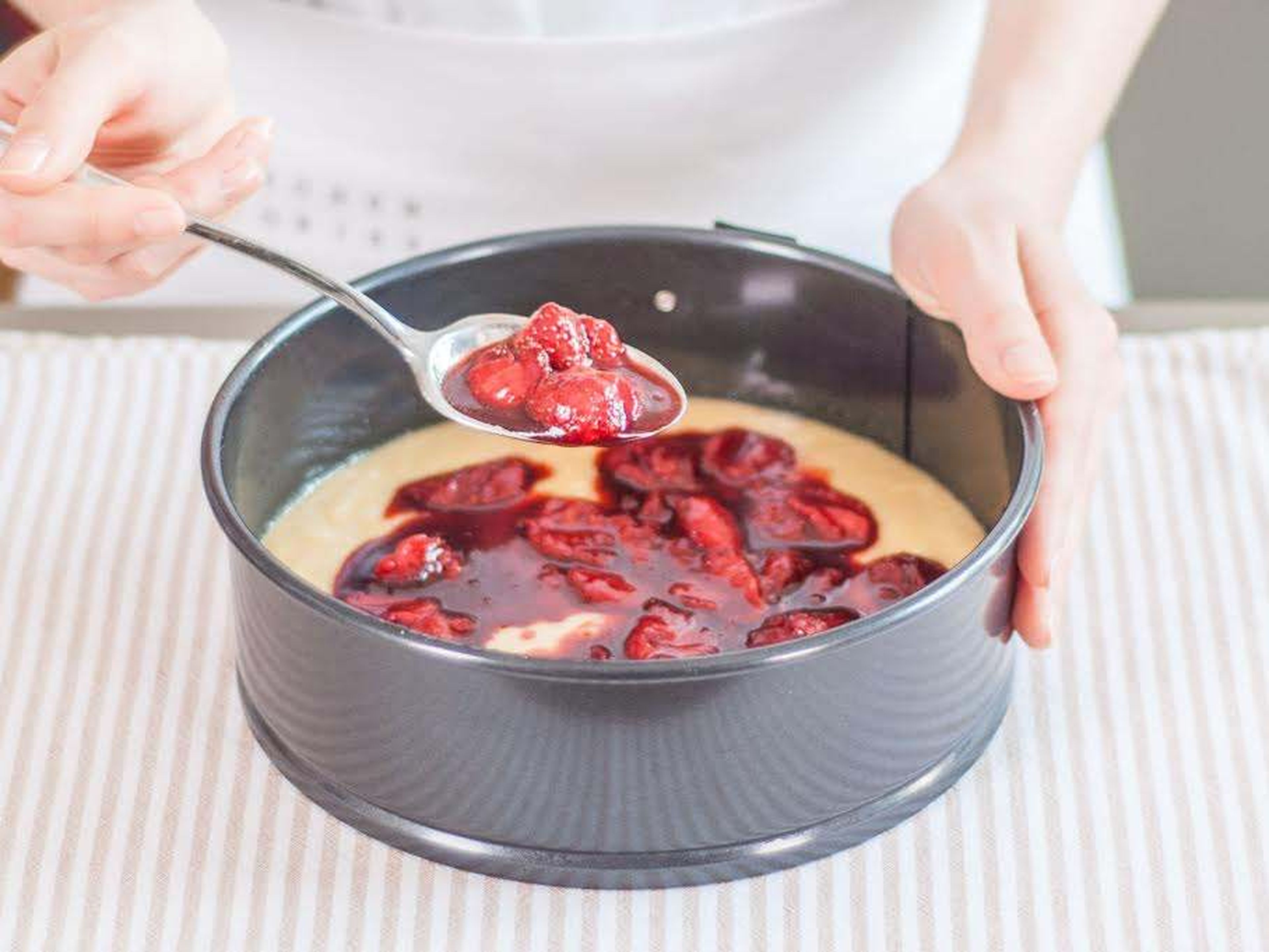 Hitze des Backofens auf 175°C reduzieren. Springform mit Öl einfetten und eine Hälfte des Teigs in die Kuchenform geben. Balsamico-Erdbeeren mit der kompletten Flüssigkeit darauf verteilen, dabei etwa daumendick Abstand zum Rand lassen.