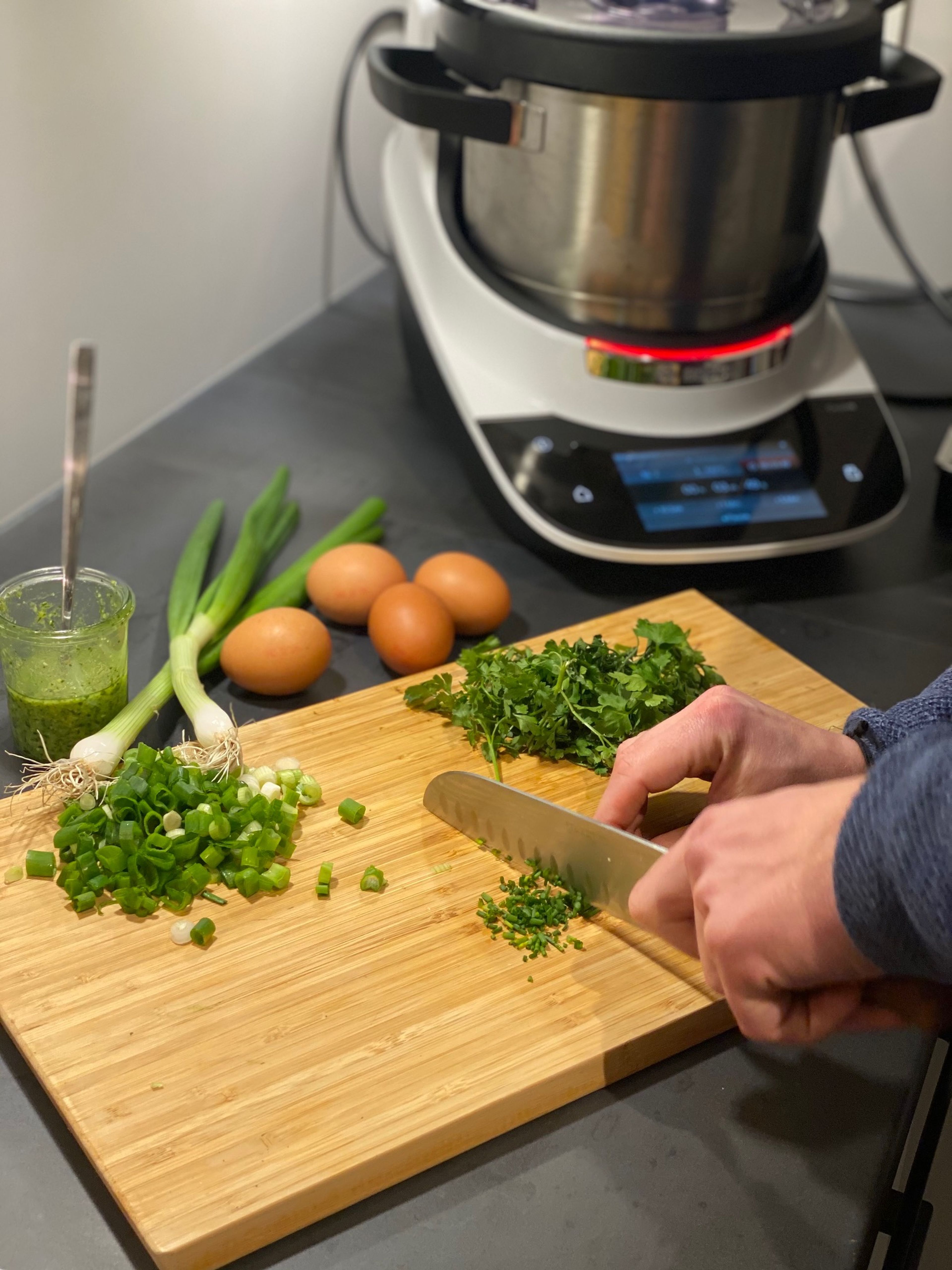 Nun wird das Gemüse (Zucchini, Frühlingszwiebel), die Petersilie und der Knoblauch mit einem Küchenmesser kleingeschnitten.