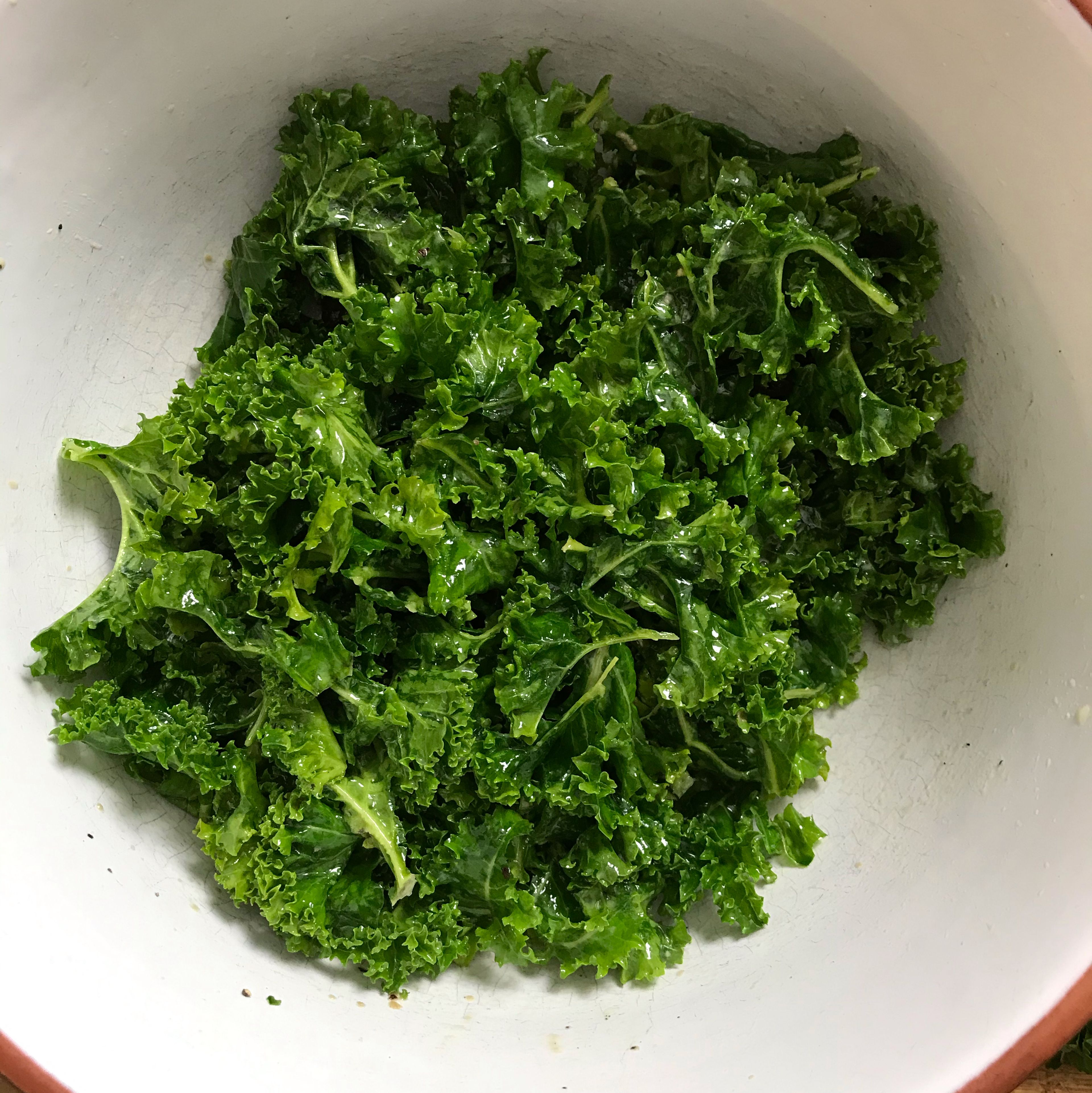 Mix olive oil with lemon juice, salt, pepper, and nutritional yeast flakes. Add the kale and knead everything with your hands.