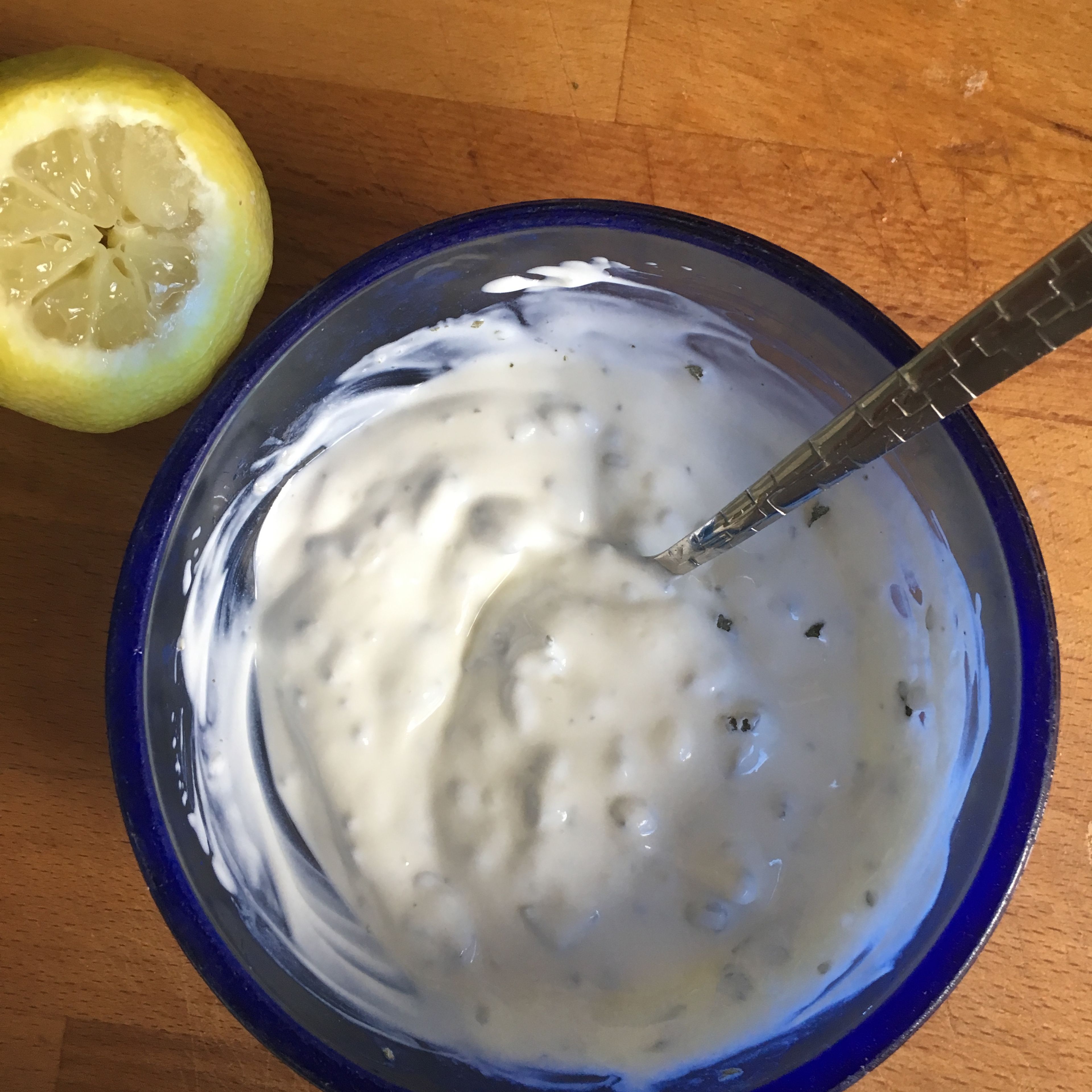 Minze fein hacken, mit Joghurt vermengen und mit Zitrone abschmecken. 