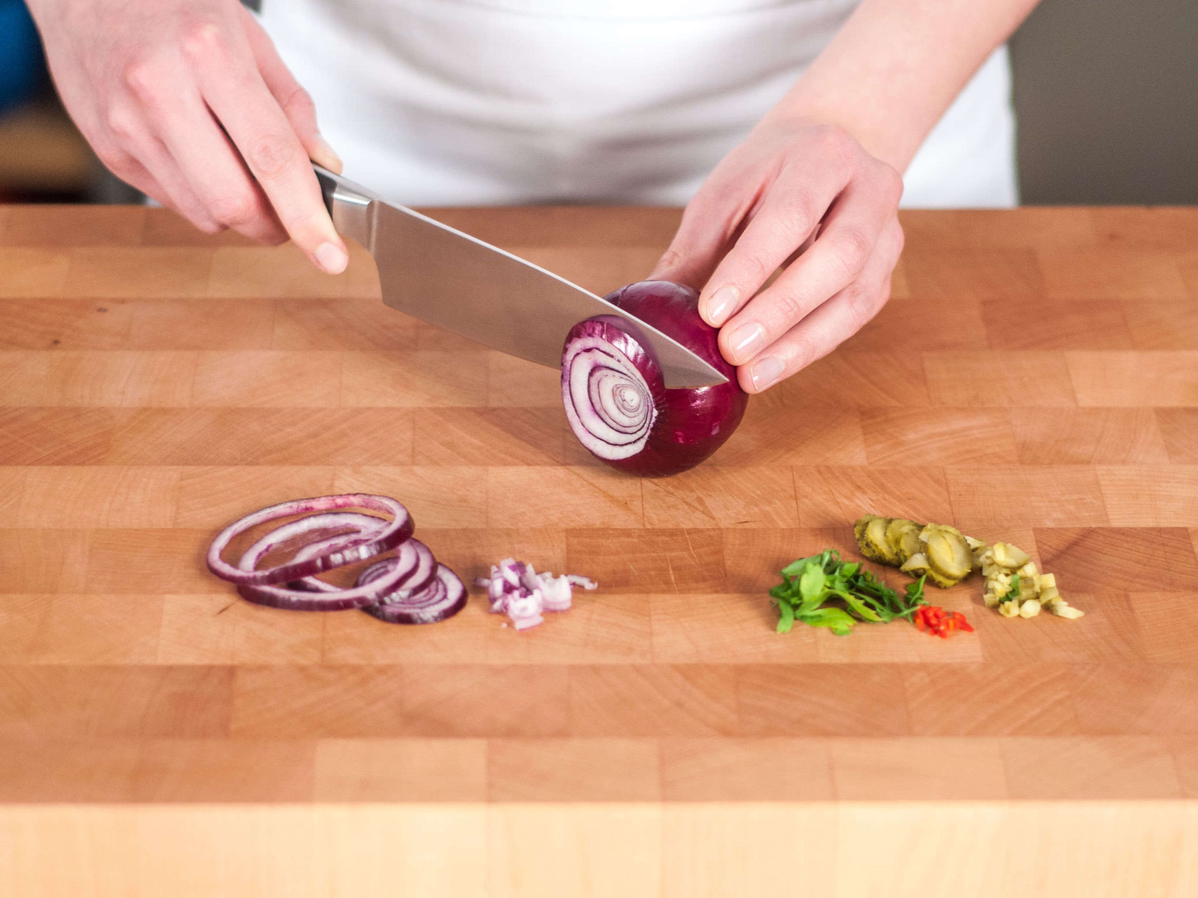 Chop pickles, reserving pickle water. Finely chop red chili, parsley, and chives. Slice red onion into fine rings.
