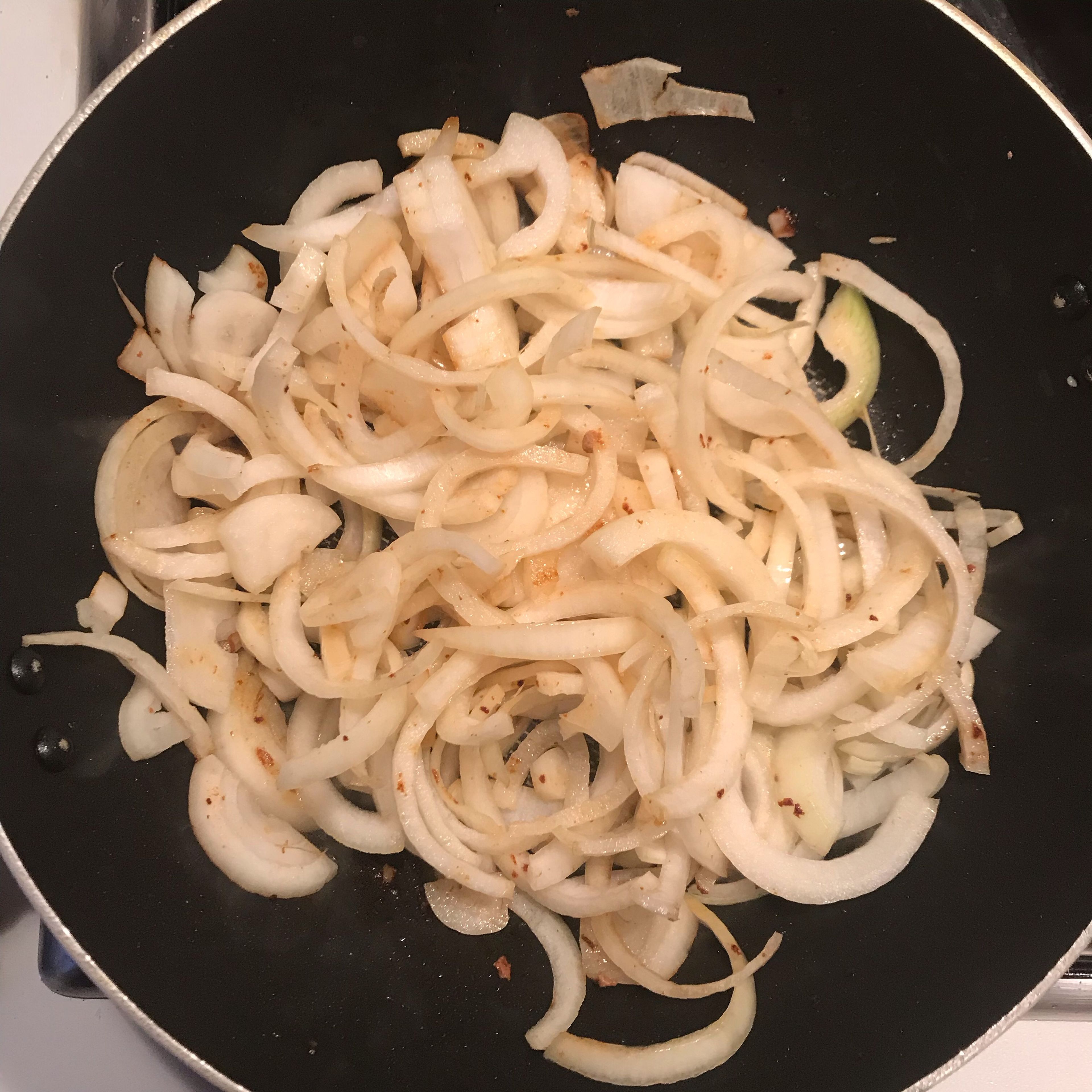 Peel and halve the onions and cut into crescent slices, about 1cm wide at the thickest part. Sauté these in the pan in which you cooked the sausages until soft but not coloured.
