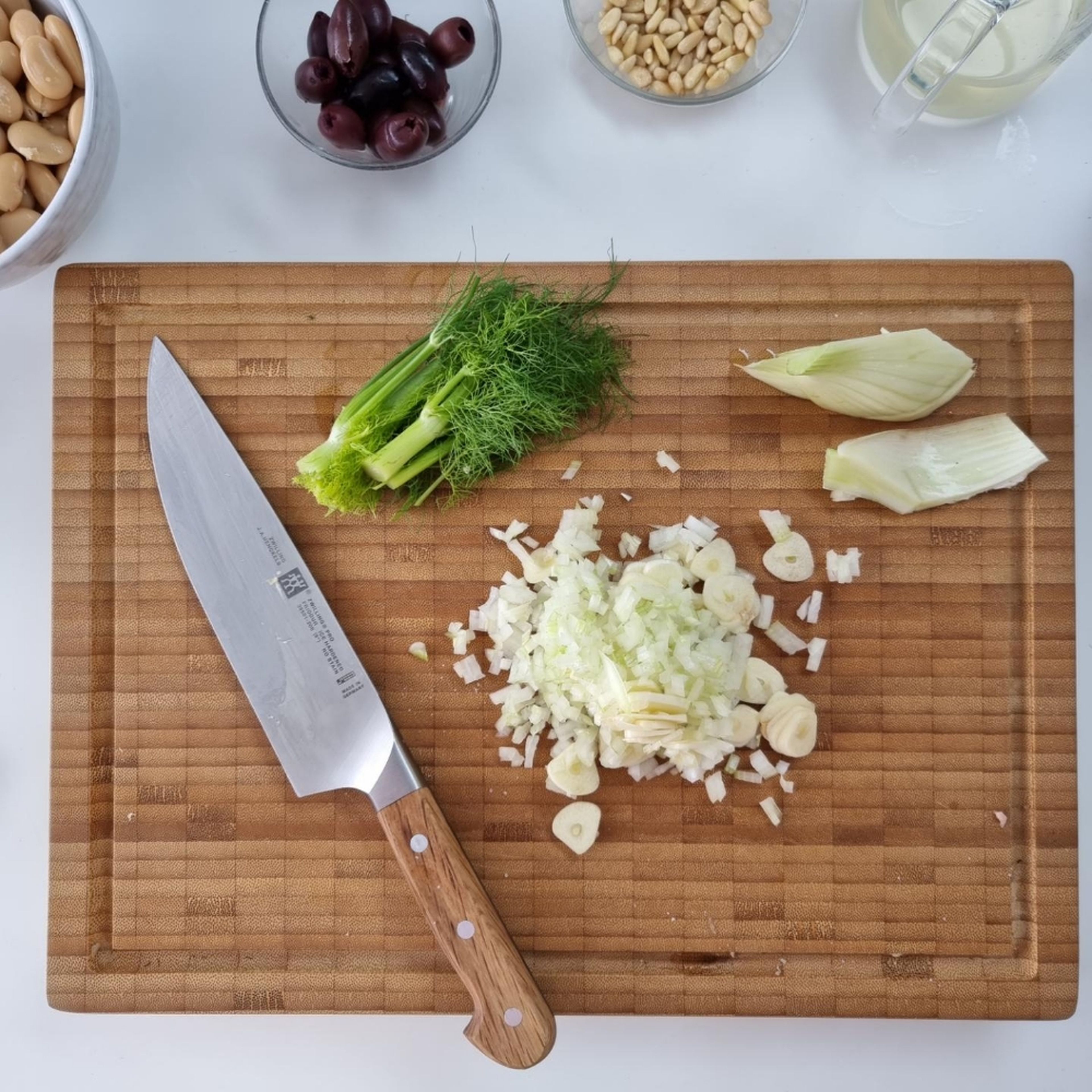 Cut chicken into bite-sized cubes. Clean fennel, quarter and remove the stalk. Drain the white beans well over a sieve. Peel and finely dice garlic and onion.