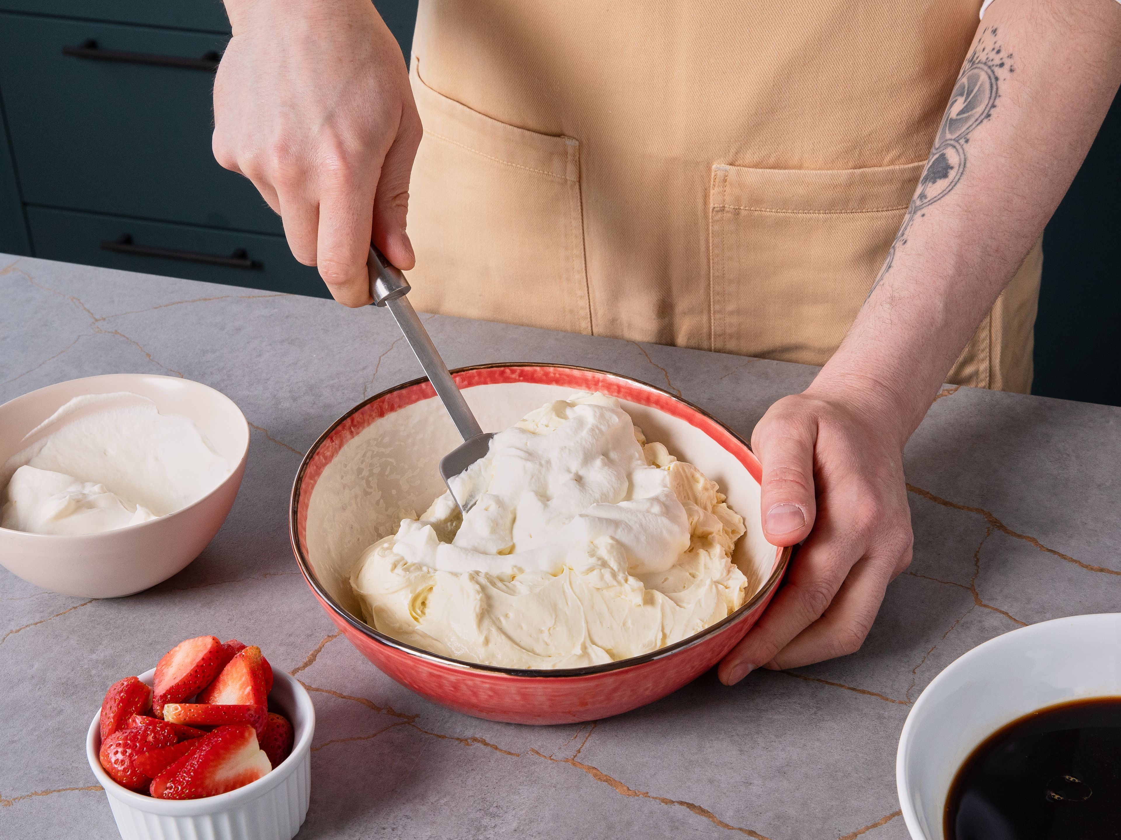 Die Eier trennen und die Eigelbe mit Honig und Vanilleextrakt in einer Schüssel mit dem Handrührgerät cremig aufschlagen. Mascarpone nach und nach unterrühren, bis eine glatte Masse entsteht. Schlagsahne separat steif schlagen und unter die Mascarponecreme heben.