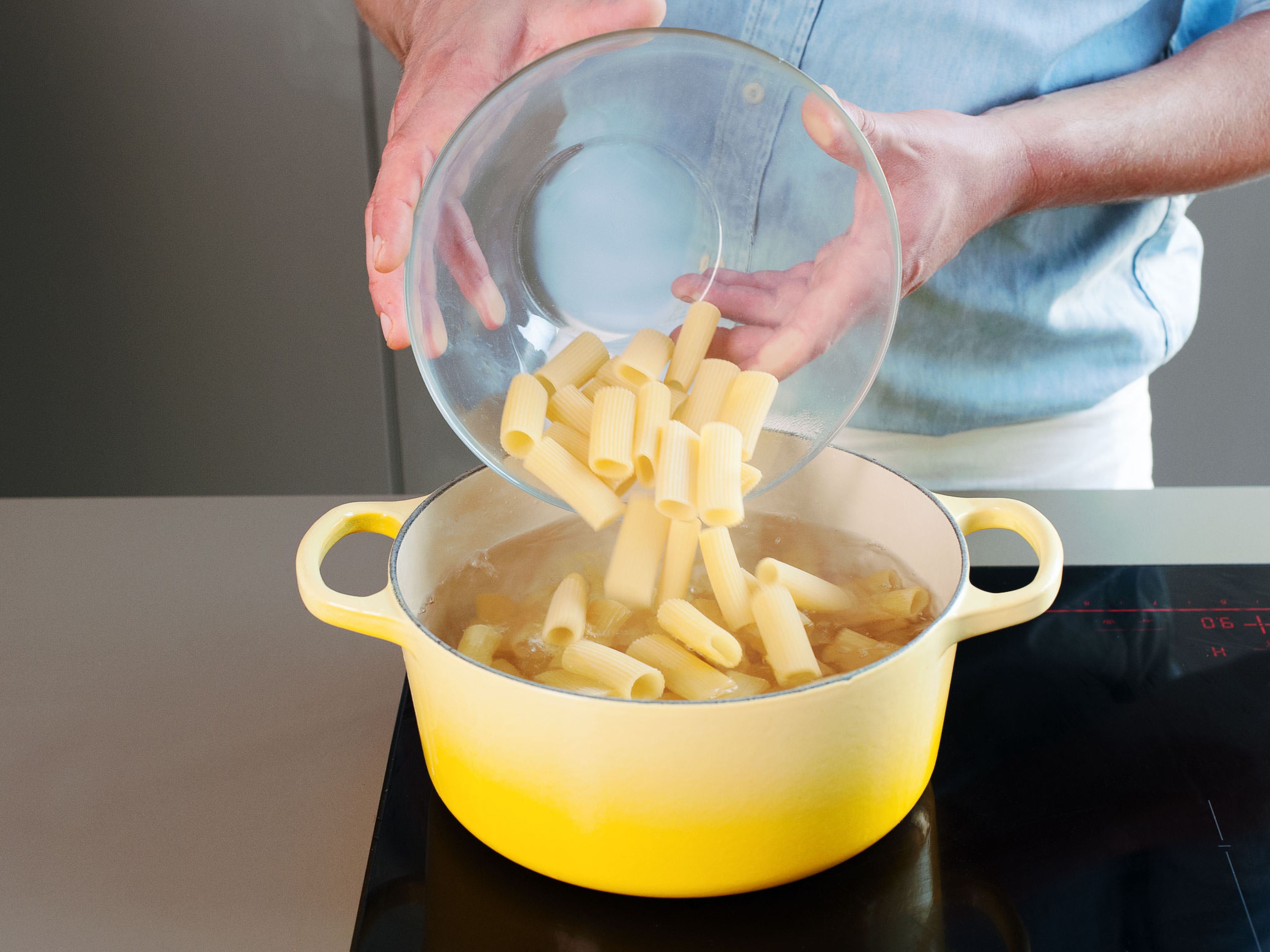 Einen großen Topf zu Hälfte mit Wasser füllen und auf hoher Stufe zum Kochen bringen; anschließend Salz hinzugeben. Rigatoni in das kochende Wasser geben und je nach Packunsanweisung al dente kochen, ca. 10 - 12 Min. Pasta abgießen und etwas von dem Nudelwasser zur Seite stellen.