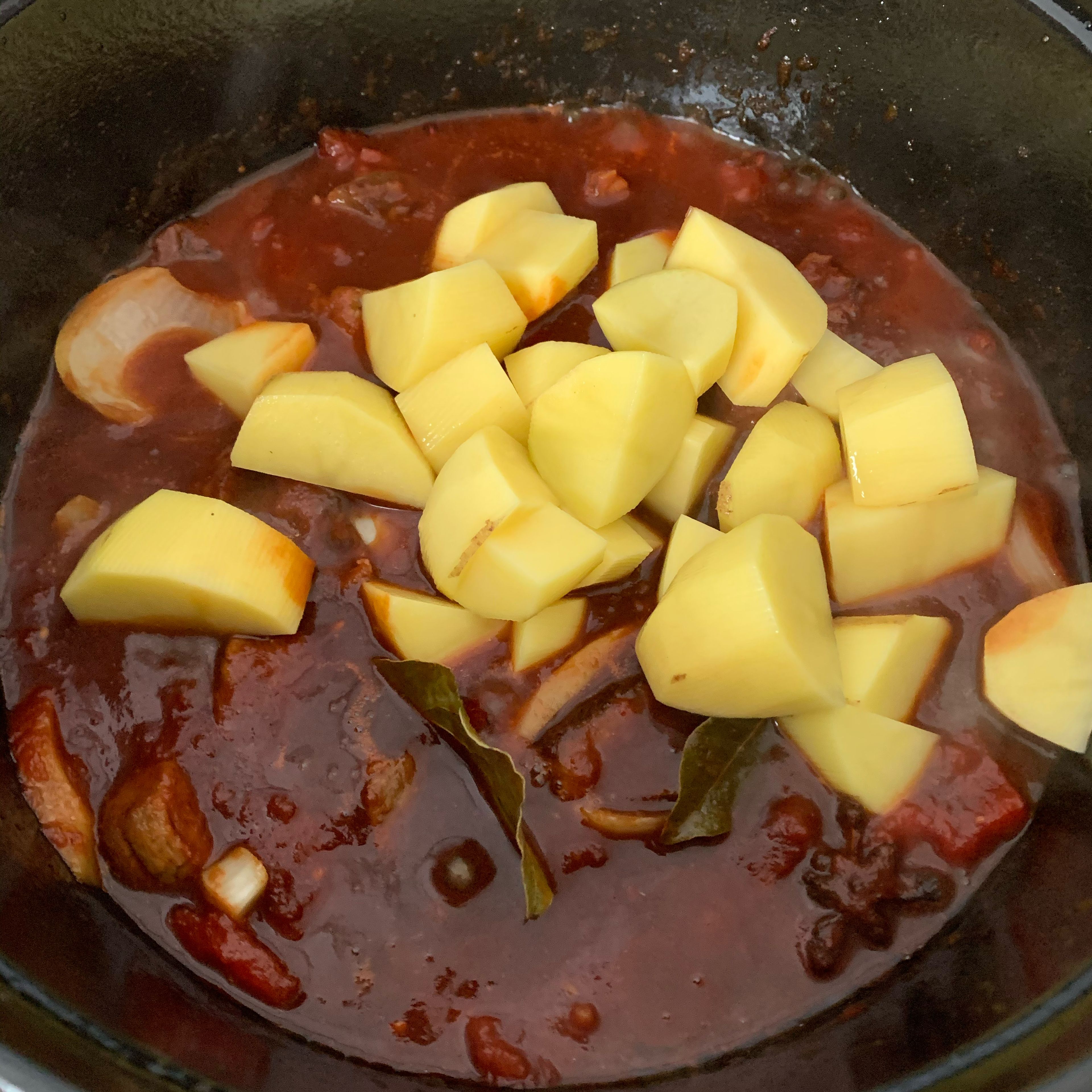 Add canned diced tomatoes with light soy sauce, dark soy sauce, remaining shaoxing wine. At last, add potatoes. Stir everything to combine. Bring to a boil. Cover with lid and simmer over low heat for 45 min. to 1 hour. If the stew is too dry, add some boiling water.